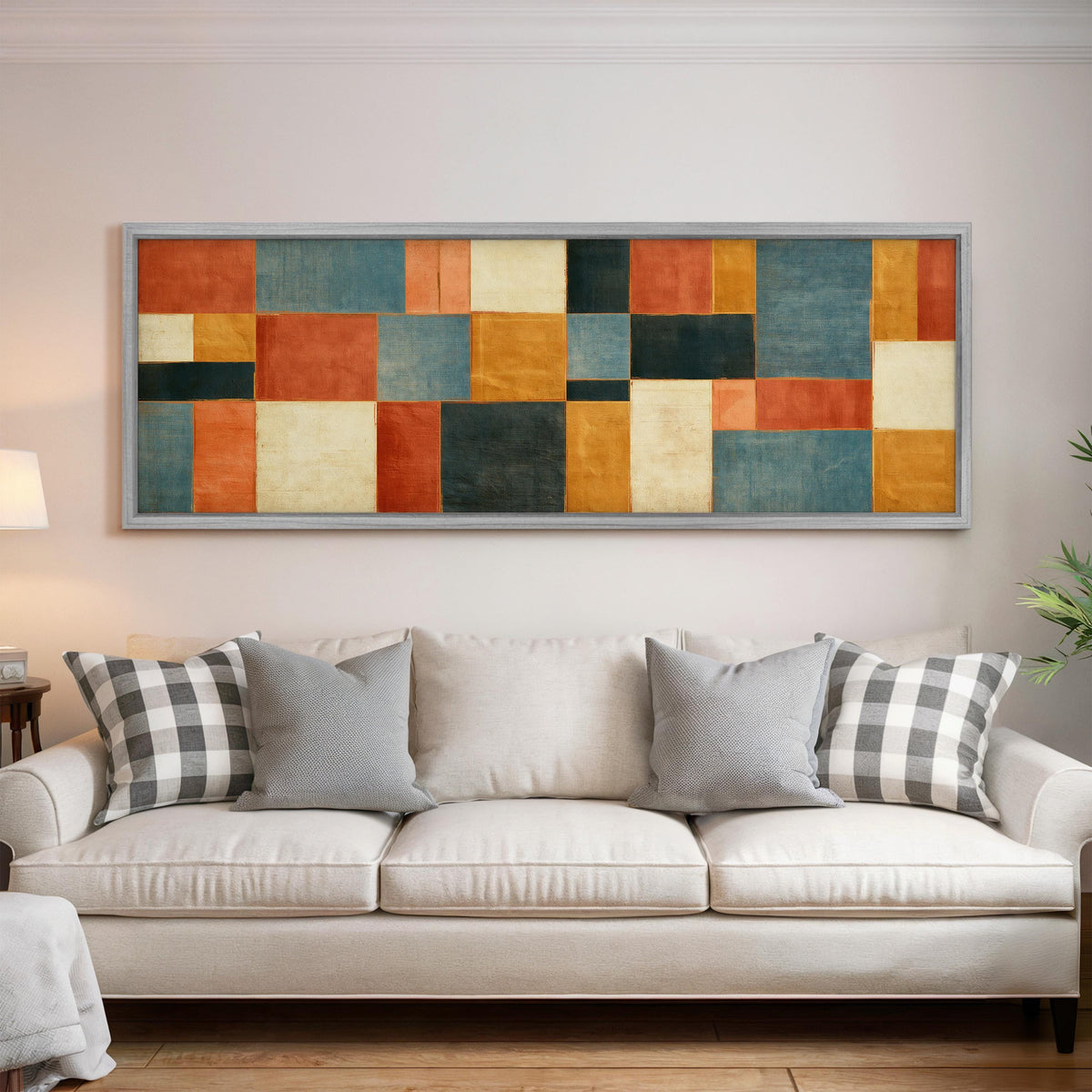 Rust, gold, navy and cream quilt blocks panoramic canvas print above a white sofa in a bright living room