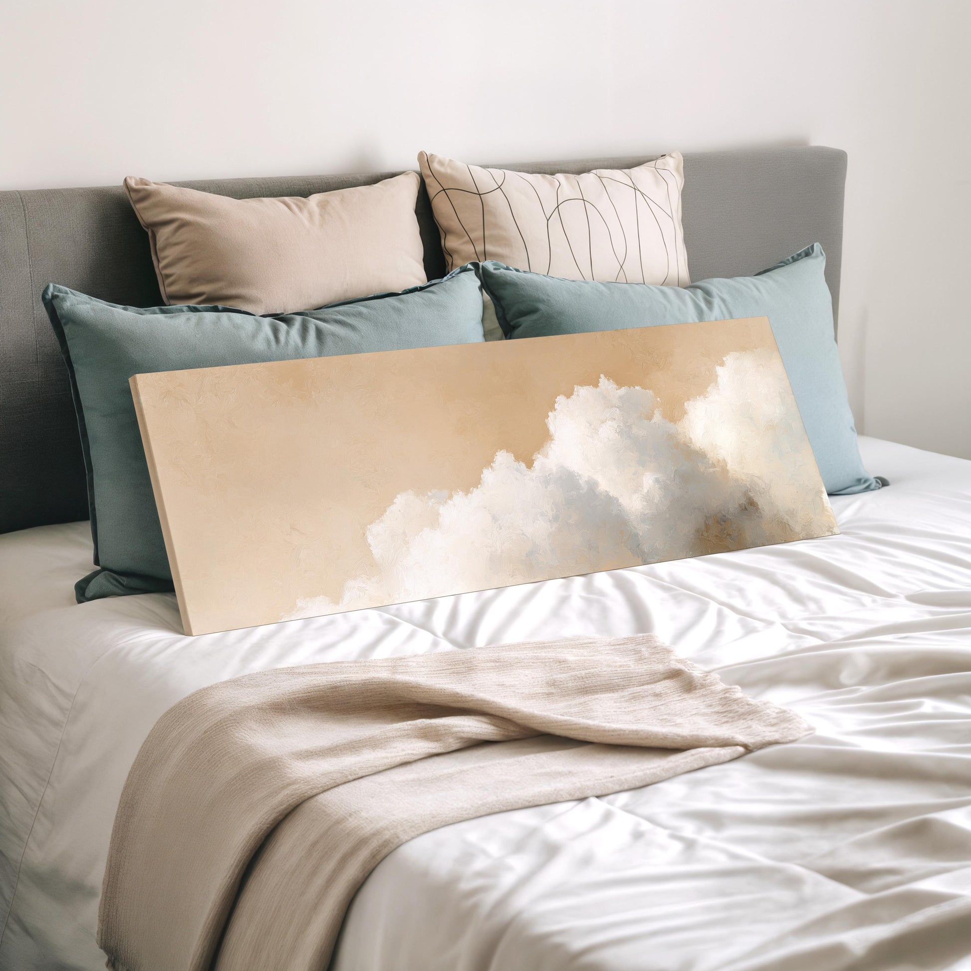 a bedroom with a bed covered in white sheets and a large canvas print of a cloud-like design on the bed.