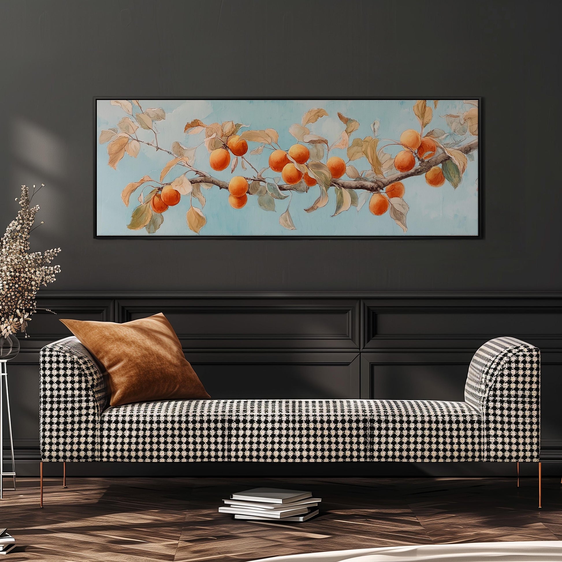 a black and white checkered sofa with a brown throw pillow, set against a dark wall with a framed painting of a branch with orange fruits hanging above it.