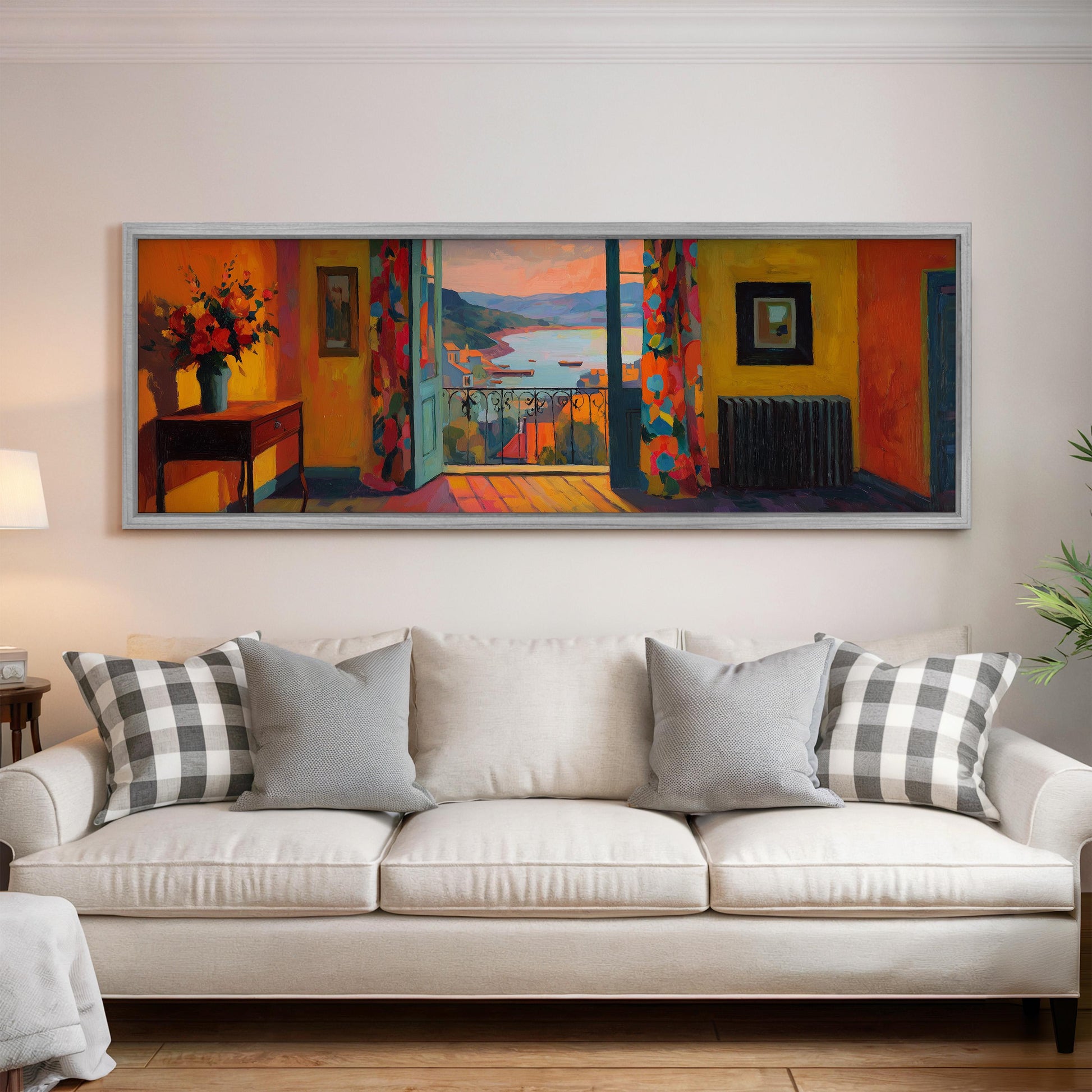 a large, colorful painting hanging on a wall above a white couch with patterned throw pillows.