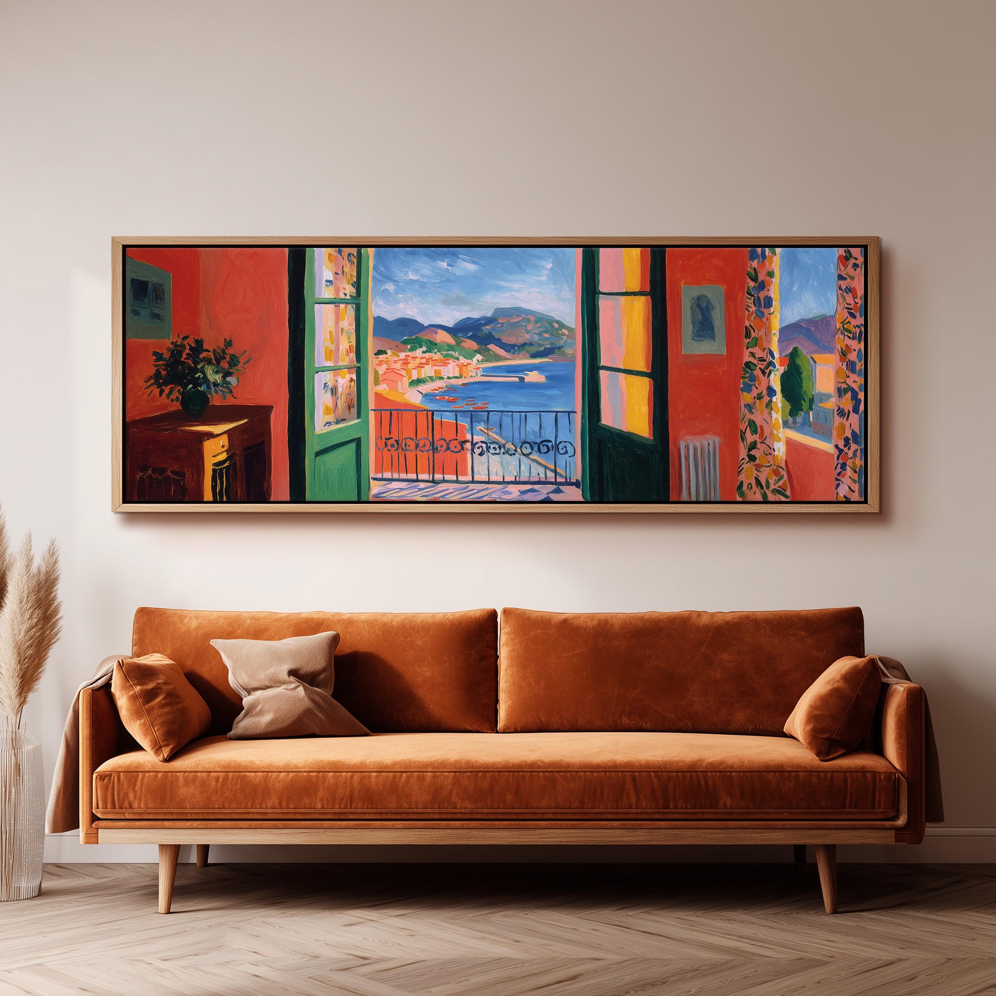 a large, colorful painting of a balcony overlooking a scenic landscape, hanging on a wall above a brown sofa.