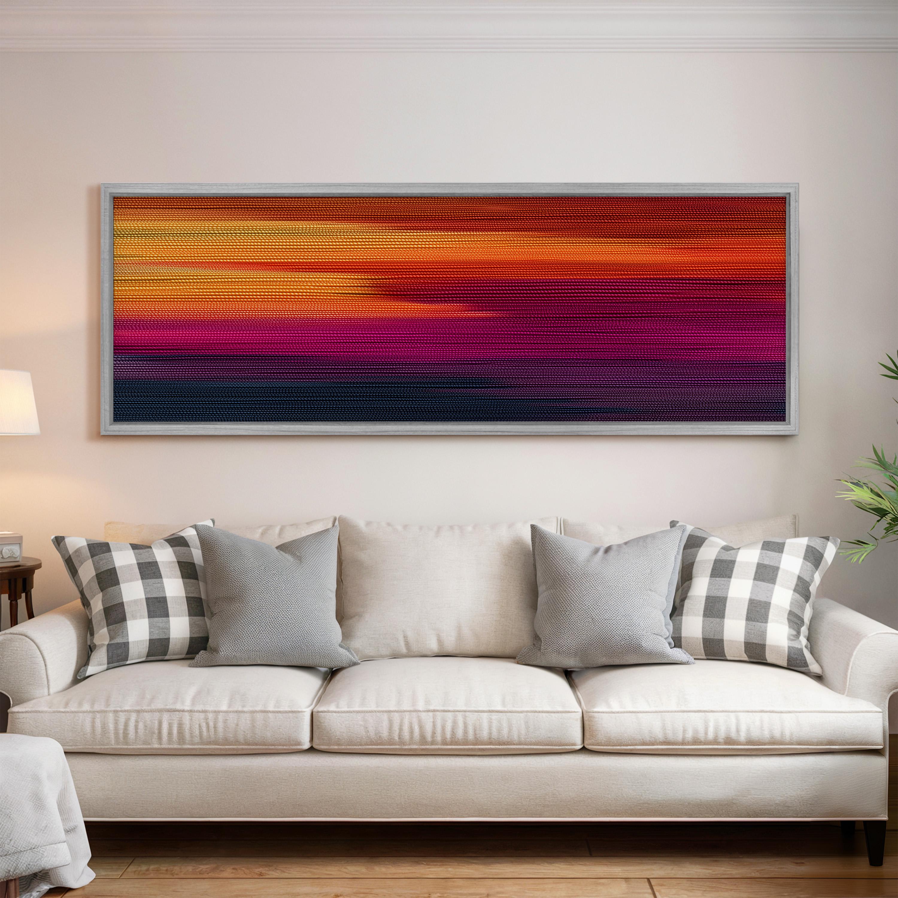 a large, colorful abstract painting hanging on a white wall above a white couch with gray and white patterned pillows.