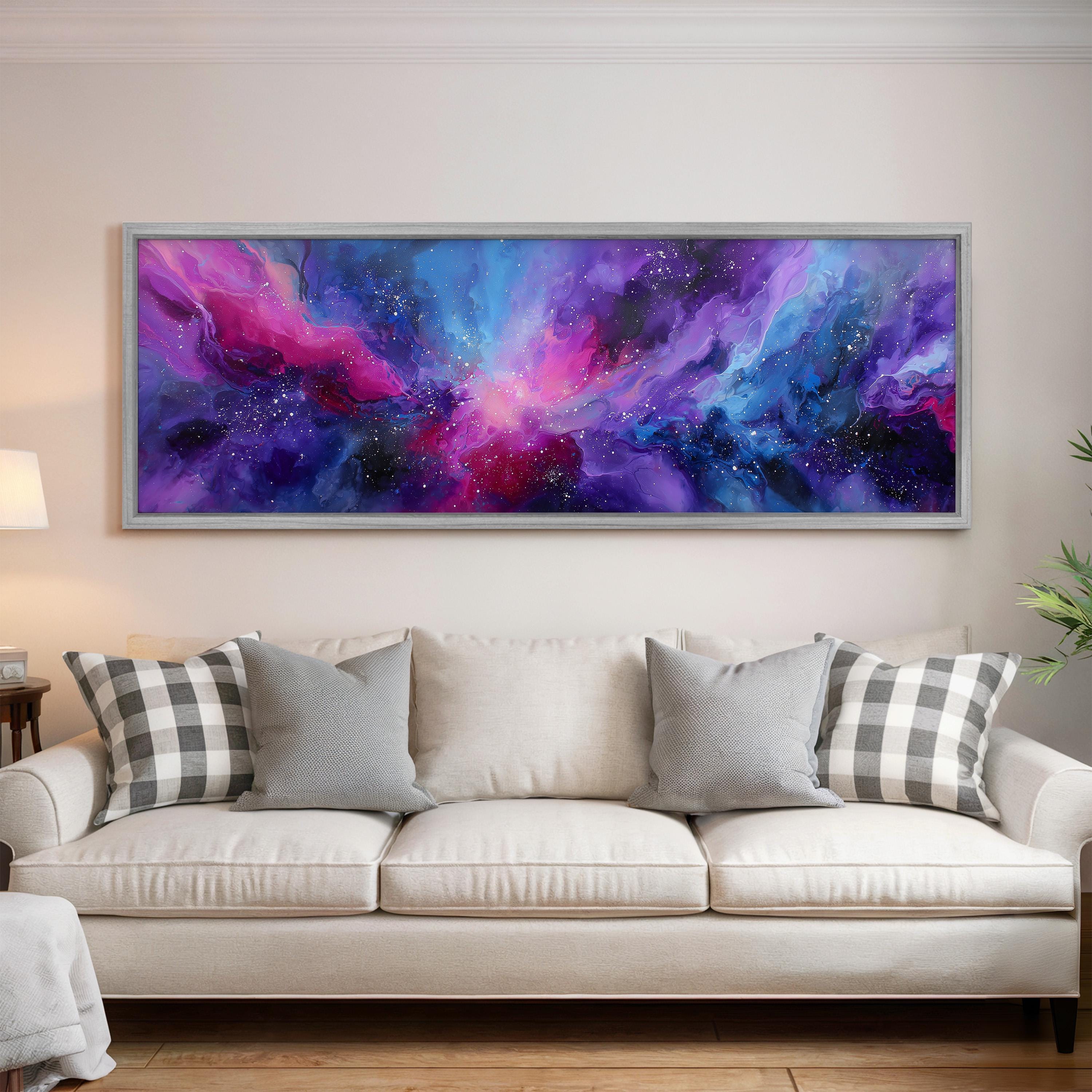 a large, colorful abstract painting hanging on a wall above a white couch with gray and white plaid throw pillows.