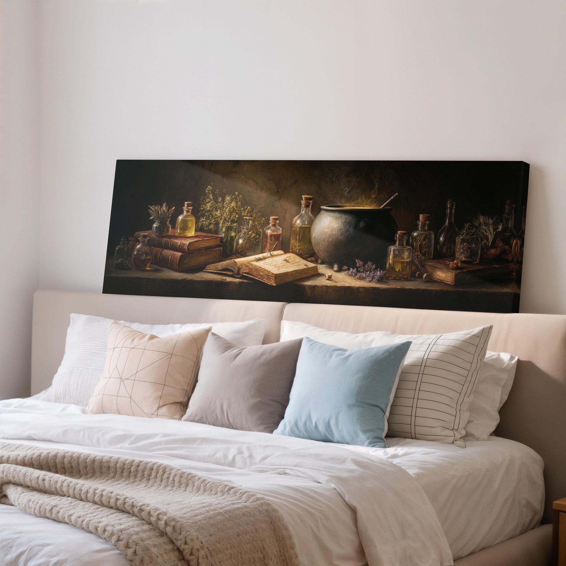 a cozy bedroom scene with a large bed adorned with white linens and a variety of pillows. Above the bed, a large canvas print features an arrangement of bottles, books, and a cauldron, creating a warm and inviting atmosphere.