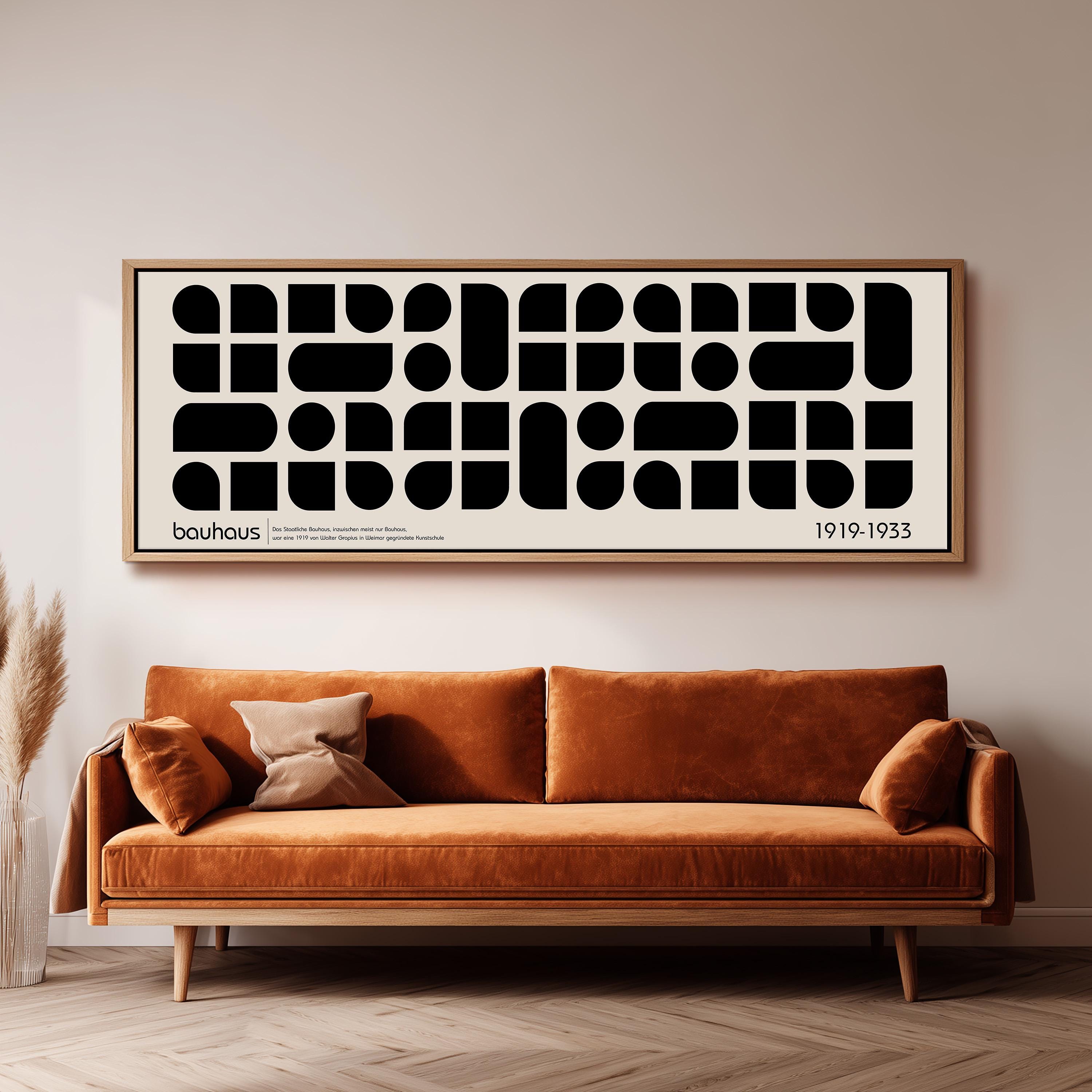 a large black and white abstract art piece hanging on a wall above a brown sofa.