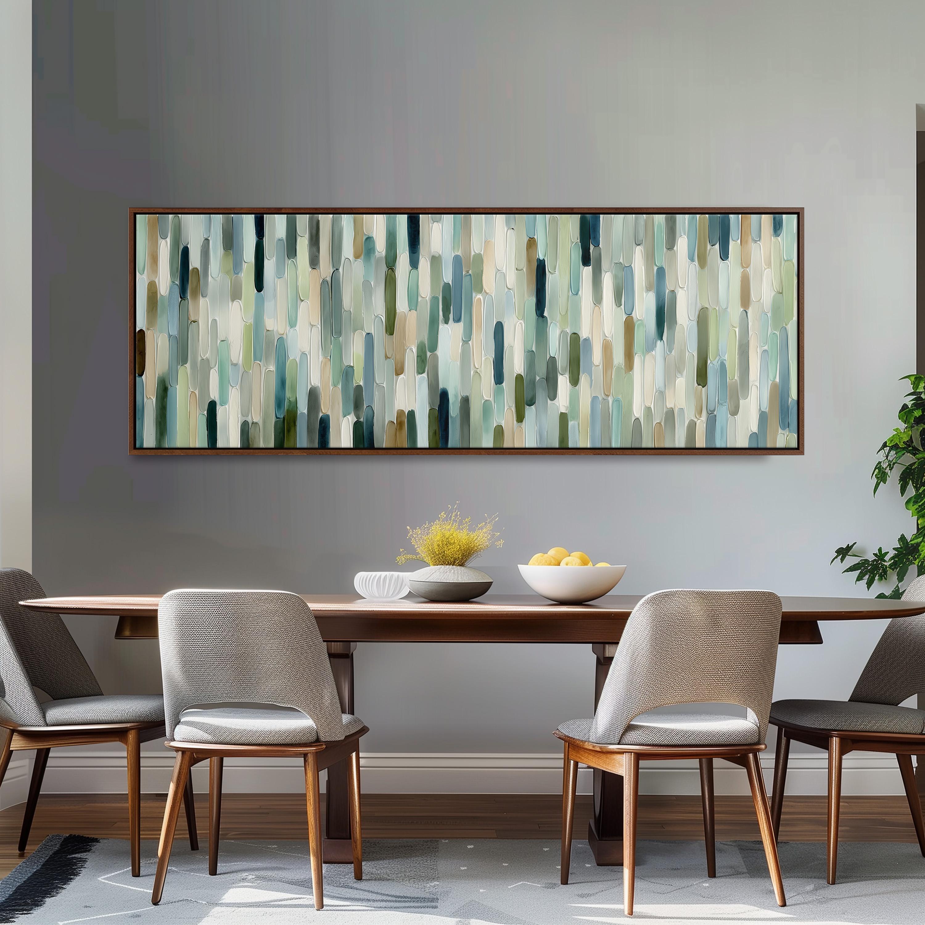 a dining room with a wooden table and four chairs. Above the table, there is a large abstract painting with vertical lines in various shades of green, blue, and gray. The table is set with a bowl of fruit and a vase of flowers, creating a cozy and inviting atmosphere.