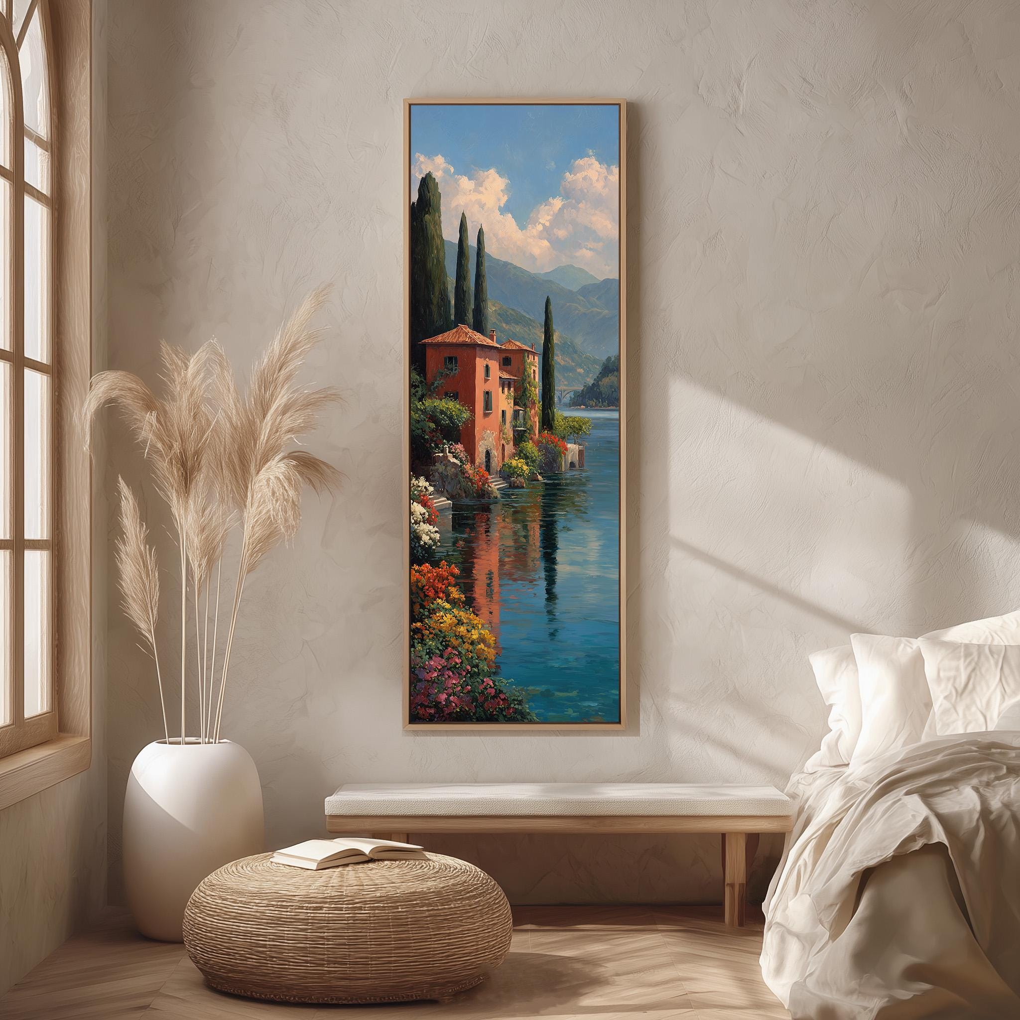a large painting of a picturesque landscape with a river, mountains, and a building, hanging on a wall in a room with a window, a bench, and a potted plant.