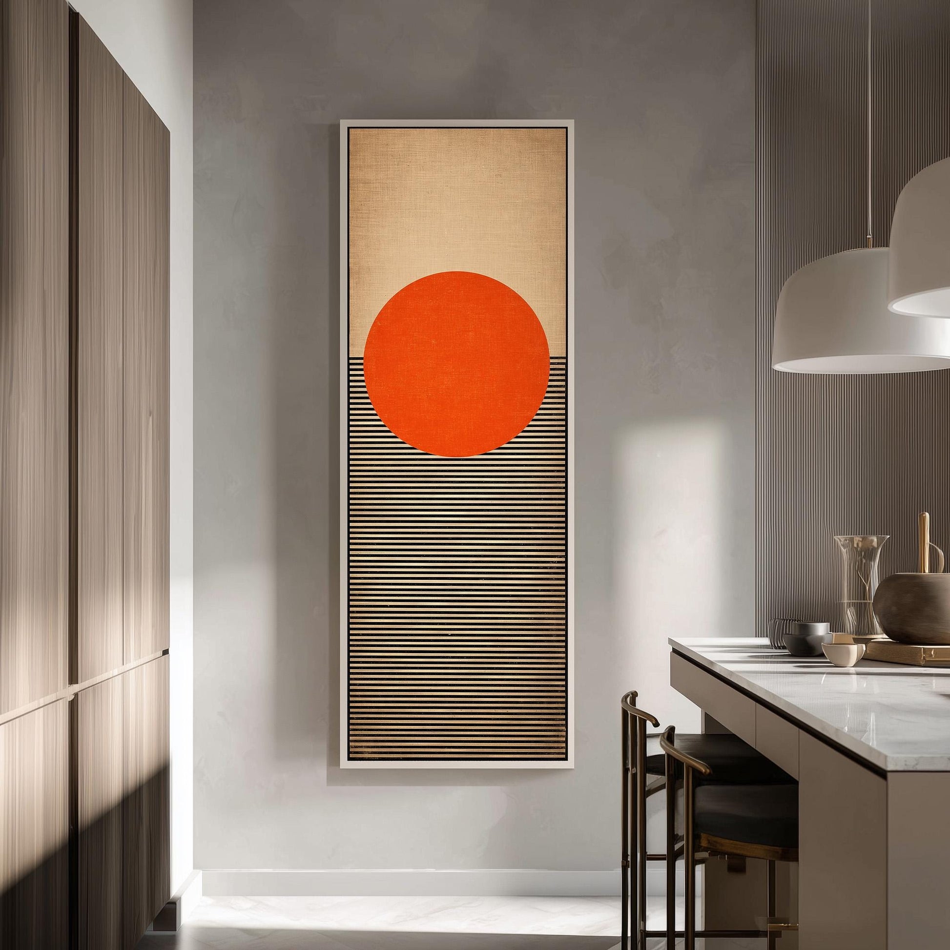a modern kitchen with a large abstract painting hanging on the wall. The painting consists of a large orange circle and horizontal stripes, creating a striking visual contrast. The kitchen is well-lit, with a countertop and chairs visible, and a pendant light hanging above the countertop.