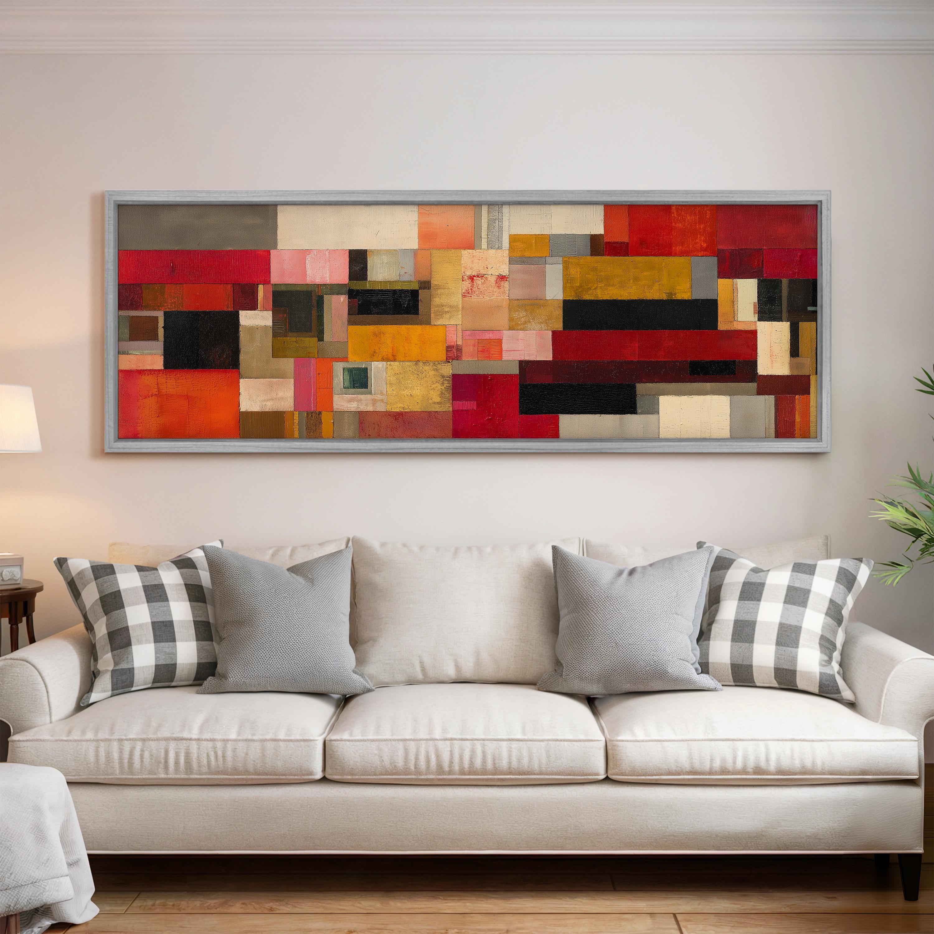 a large, colorful abstract painting hanging on a wall above a white couch with gray and white patterned pillows.