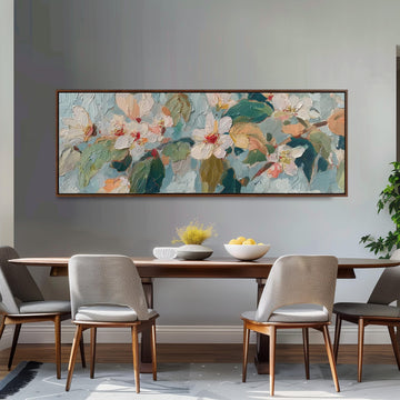 a dining room with a large painting of flowers hanging on the wall above a wooden table with four chairs. The table is set with a bowl of fruit and a vase of flowers, creating a cozy and inviting atmosphere.
