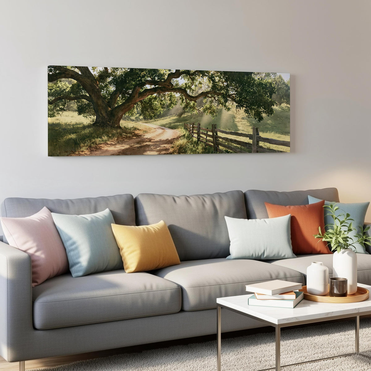 Sunlit country lane with oak trees and a wooden fence panoramic canvas print above a grey sofa in a living room