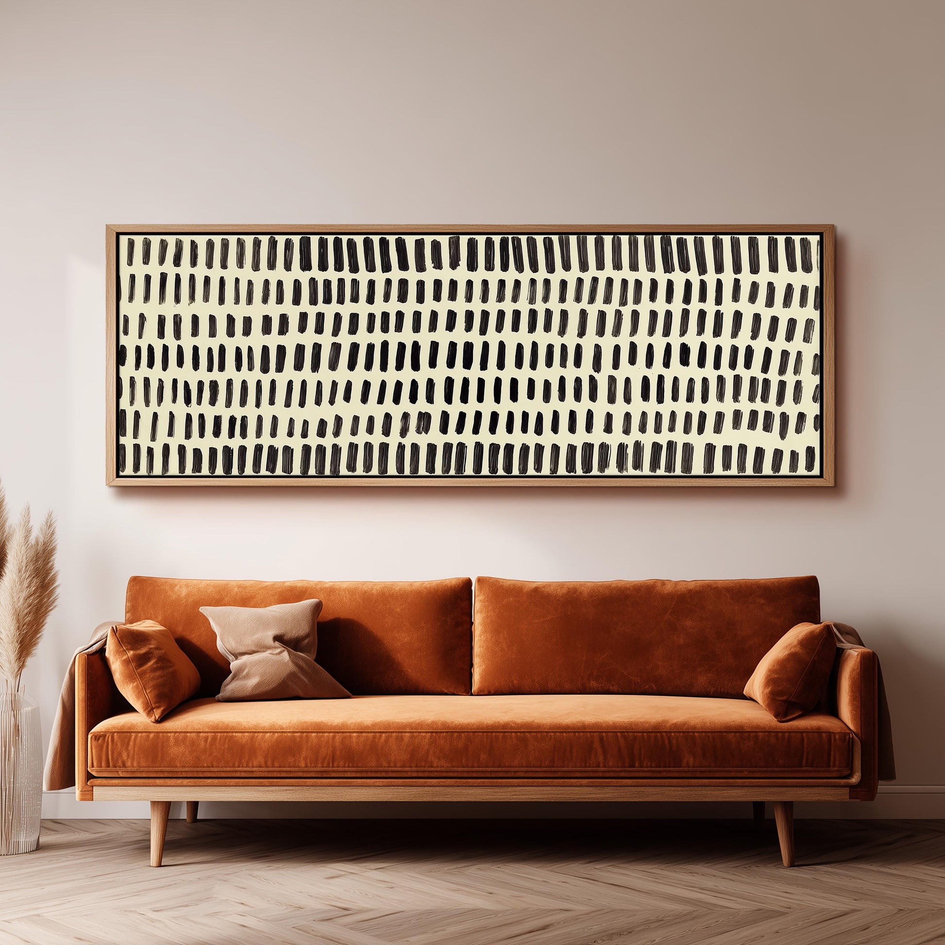 a large, rectangular abstract painting hanging on a wall above a brown sofa with two pillows.