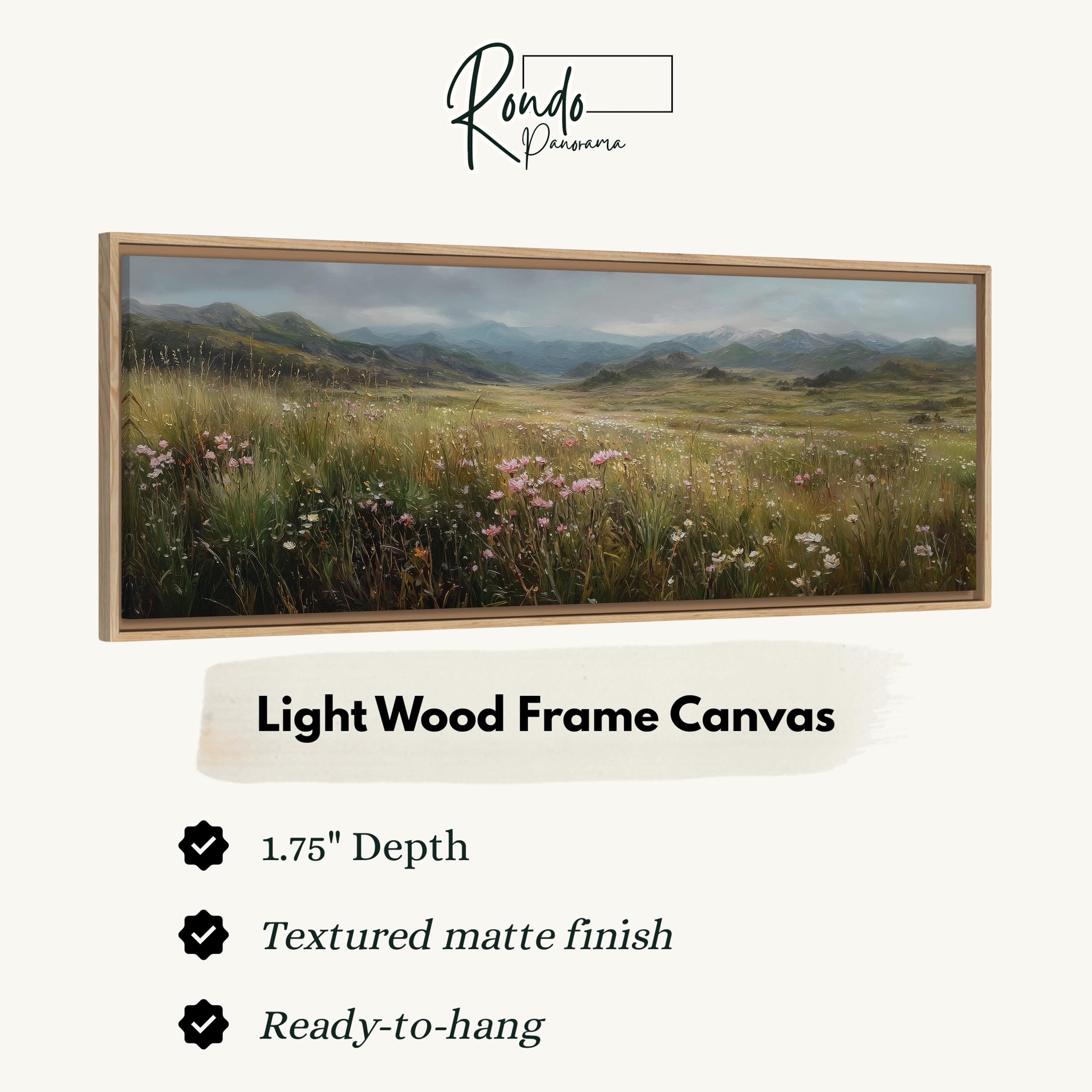 The image is a framed landscape painting depicting a field of flowers with mountains in the background.