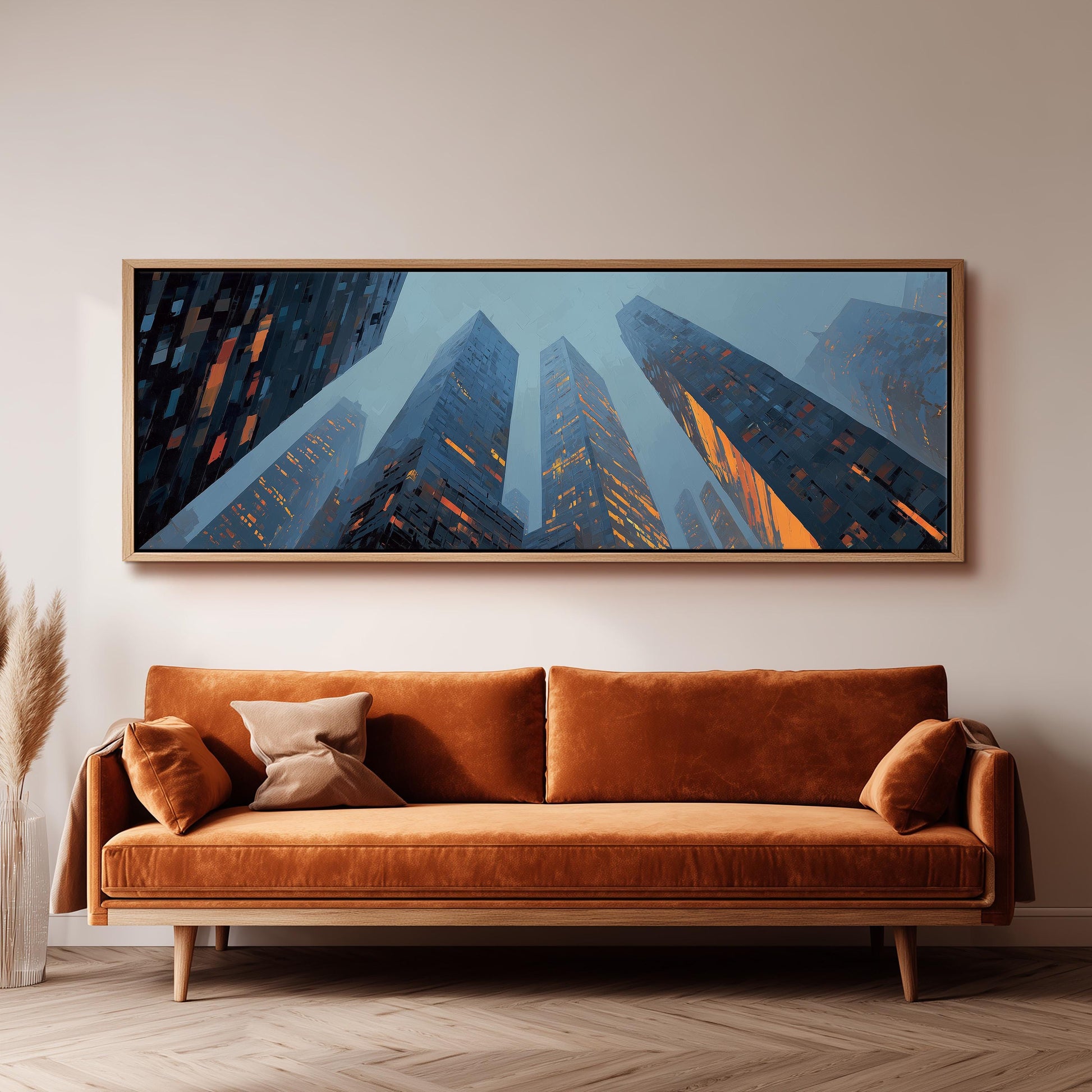 a large, framed painting of a cityscape with tall buildings, hanging on a wall above a brown sofa.