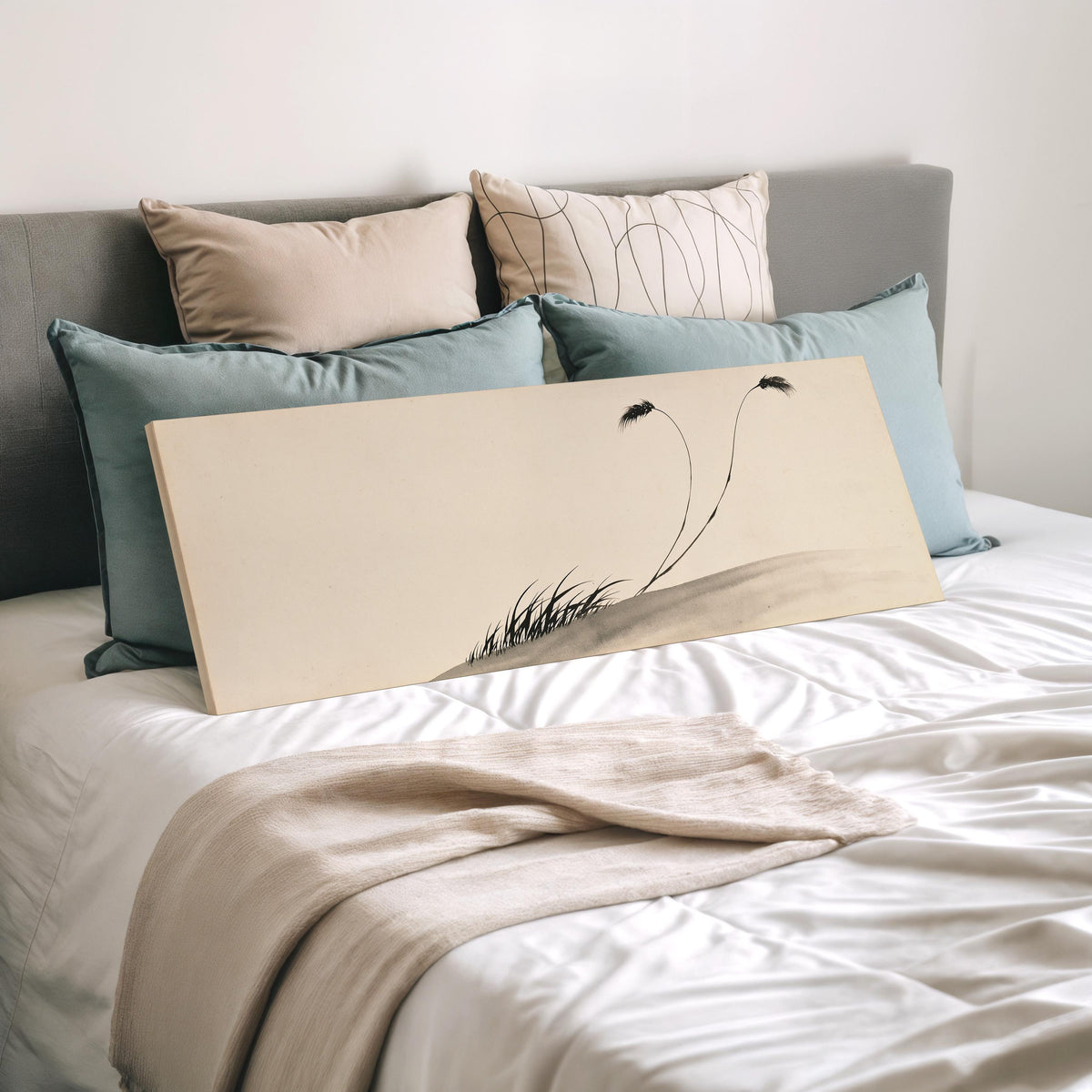 Two birds perched on bending ink reeds wide panoramic canvas print laid on a bed to show its size