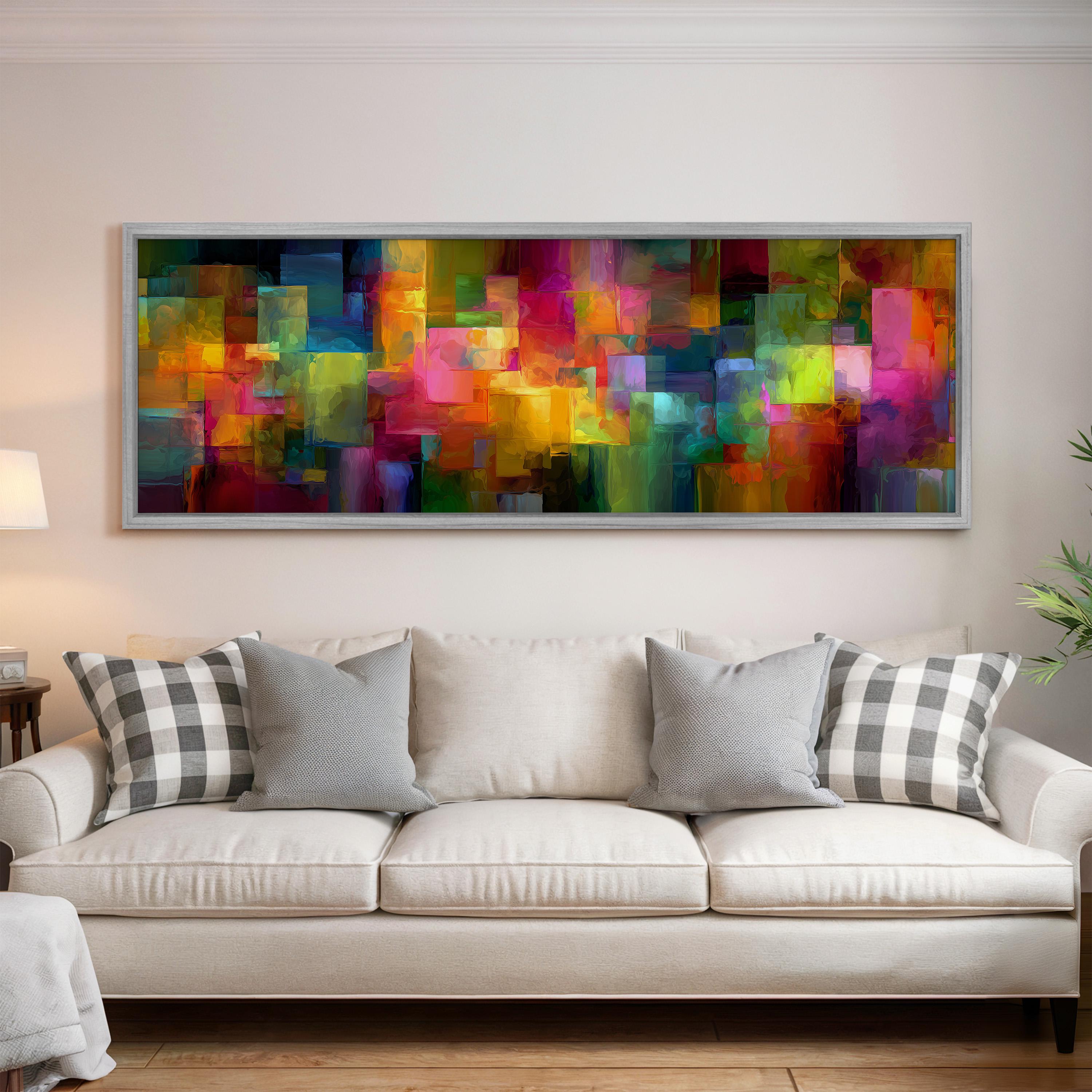 a large, colorful abstract painting hanging on a wall above a white couch with gray and white patterned pillows.