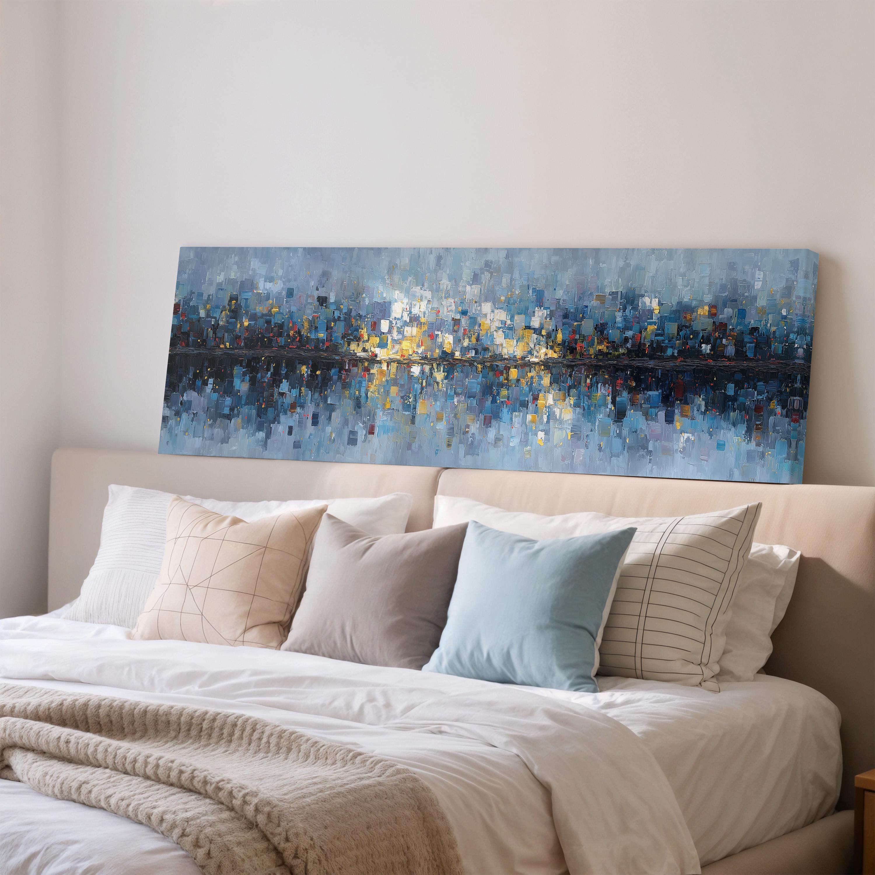 a large, colorful painting of a cityscape hanging on a wall above a bed with white bedding and pillows.