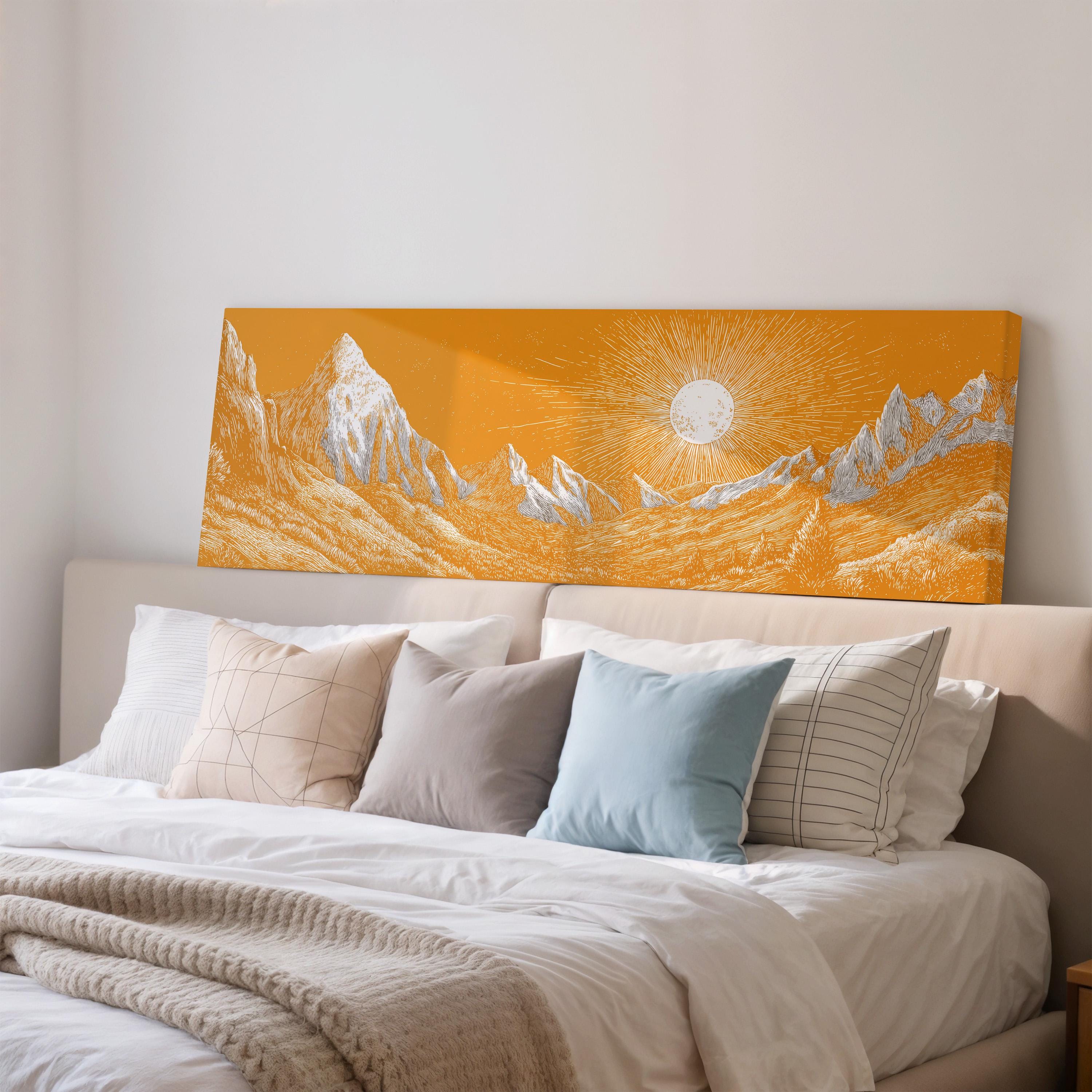 a large orange canvas print depicting a mountain landscape with a sun in the background, hanging above a bed with white pillows and a gray blanket.