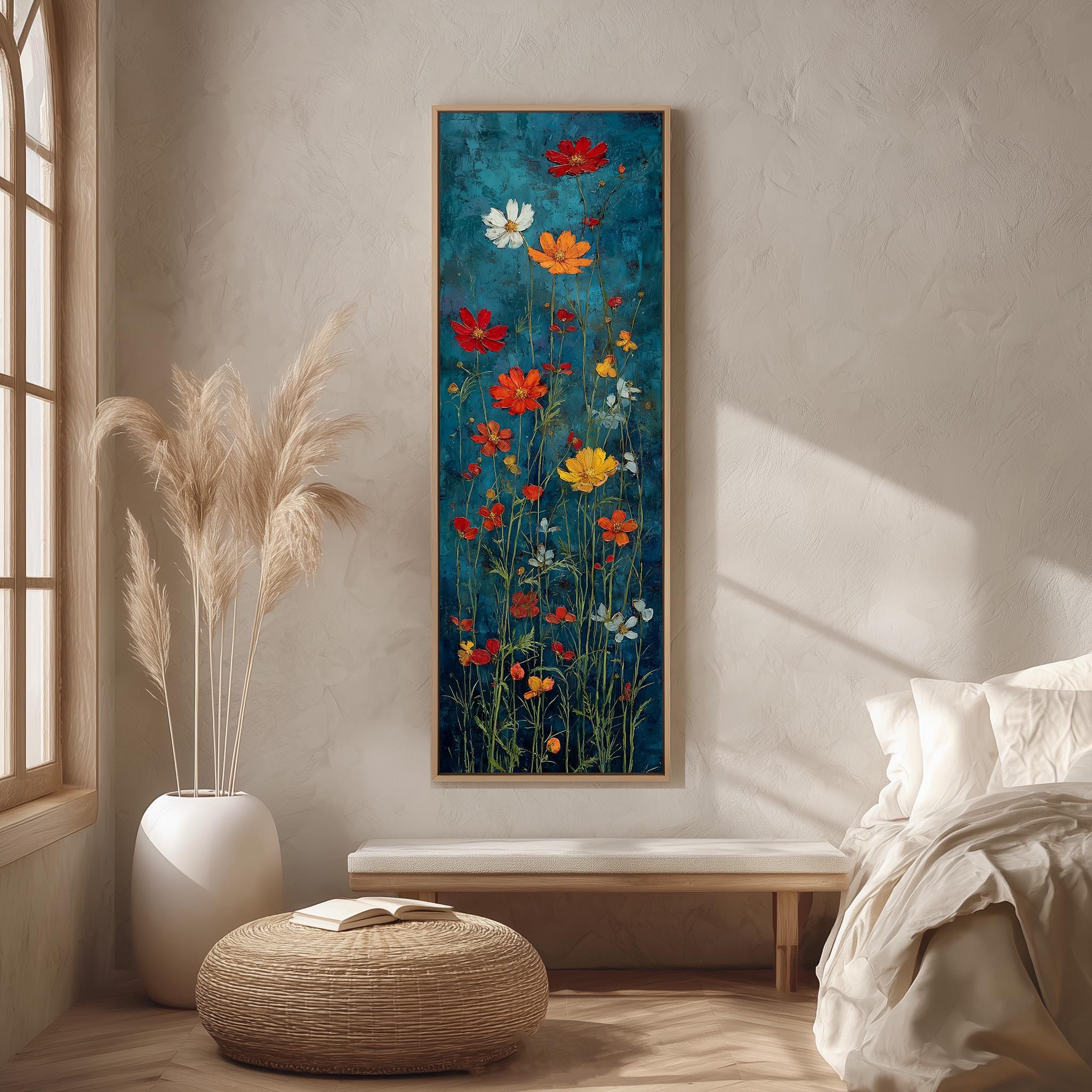 a large, colorful painting of flowers hanging on a wall in a room with a bed, a wicker ottoman, and a window.