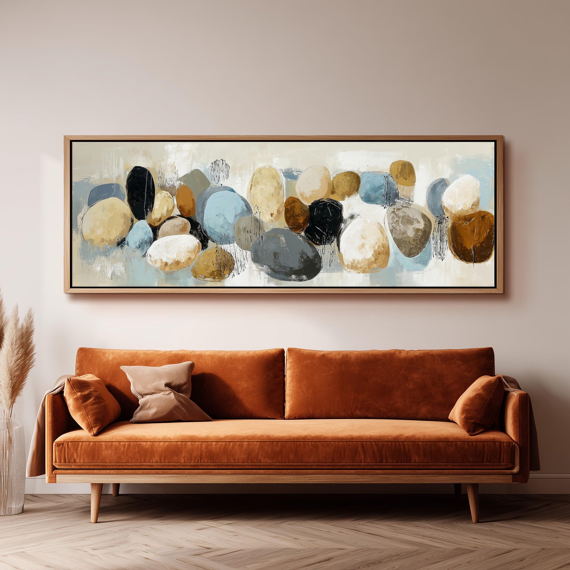 a large abstract painting hanging on a wall above a brown sofa with orange cushions.