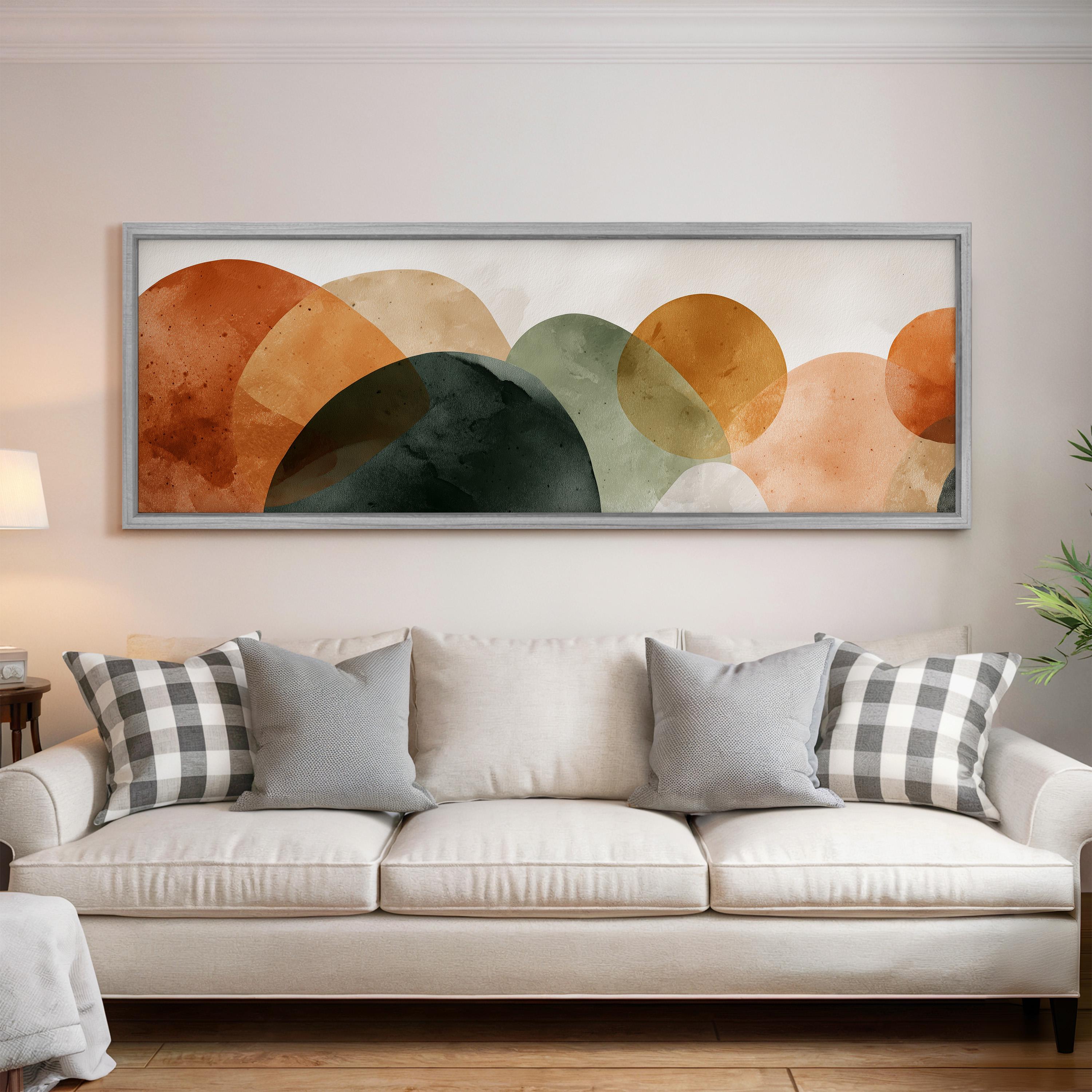 a large abstract painting hanging on a wall above a white couch with gray and white plaid throw pillows.