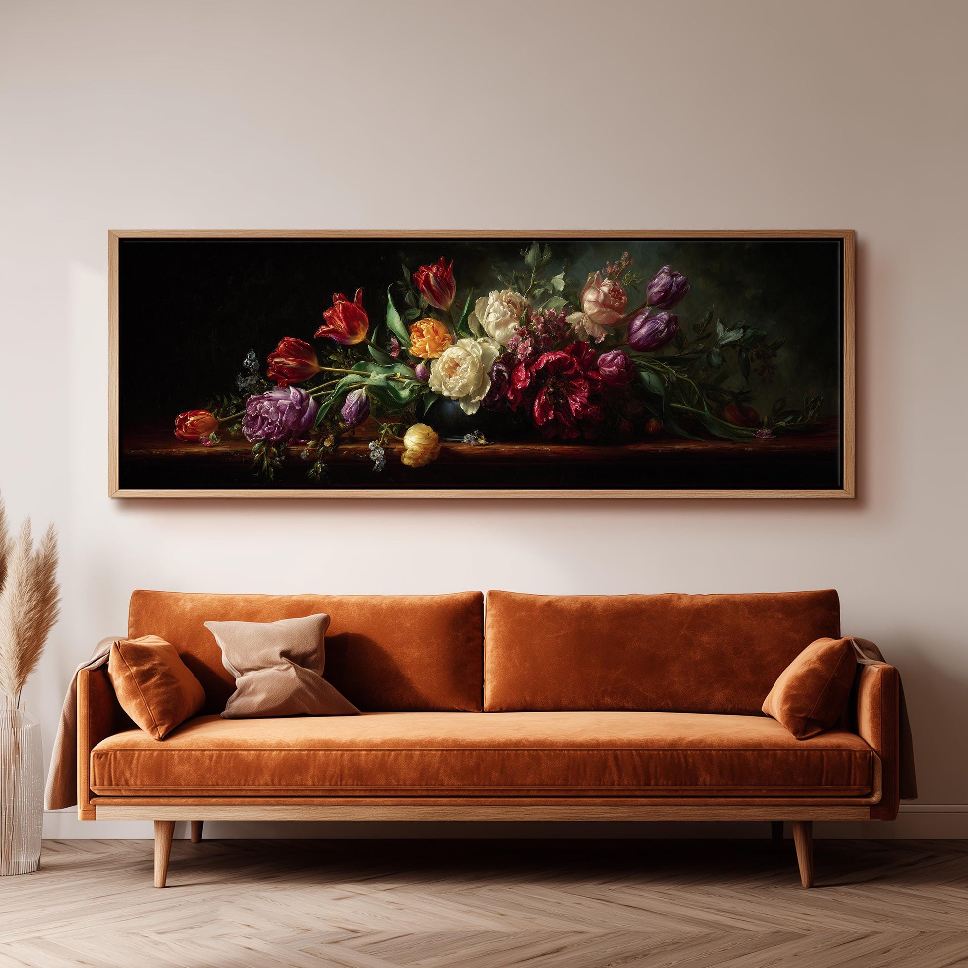 a large painting of a bouquet of colorful flowers hanging on a wall above a brown sofa.