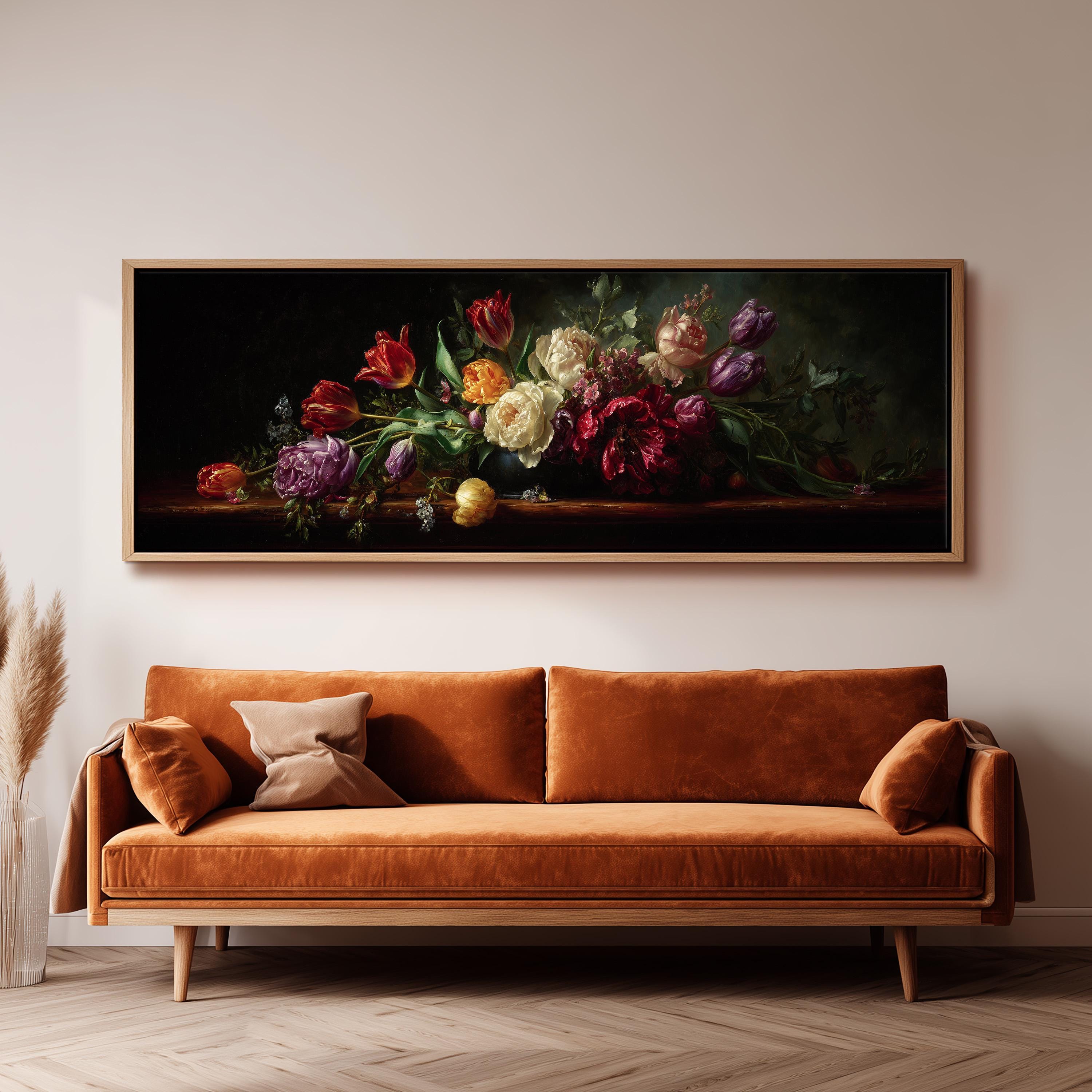a large painting of a bouquet of colorful flowers hanging on a wall above a brown sofa.