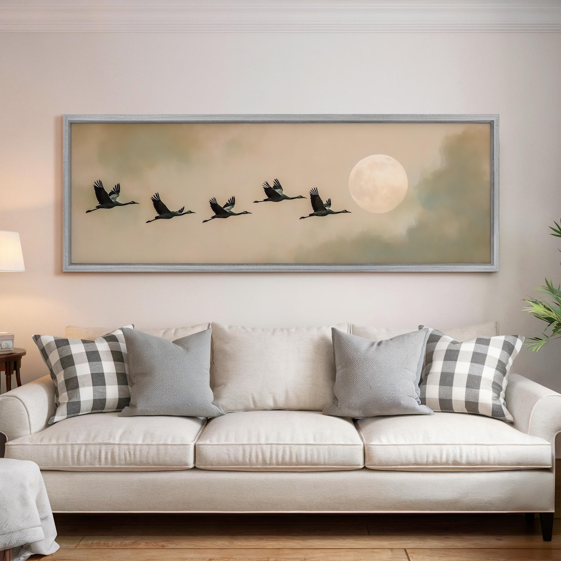 a large framed painting of a flock of birds flying in formation, with a full moon in the background.