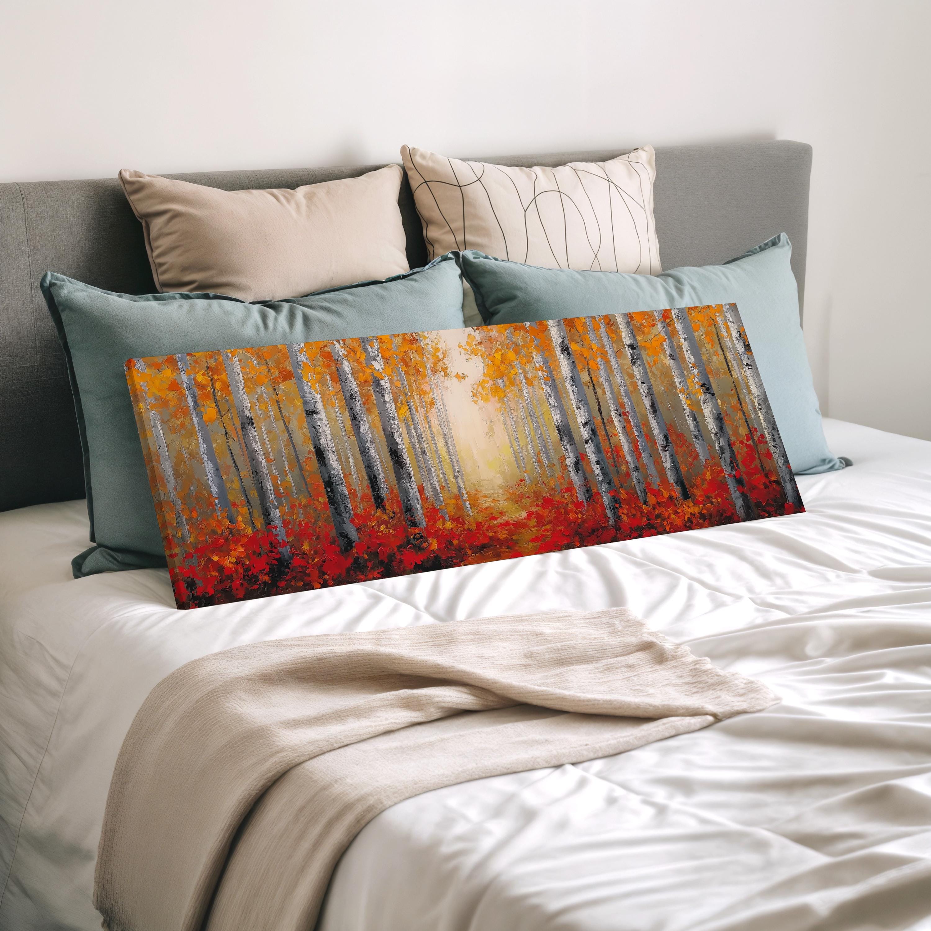 a large painting of a forest scene with a path leading through the trees, displayed on a bed with a white comforter and pillows.