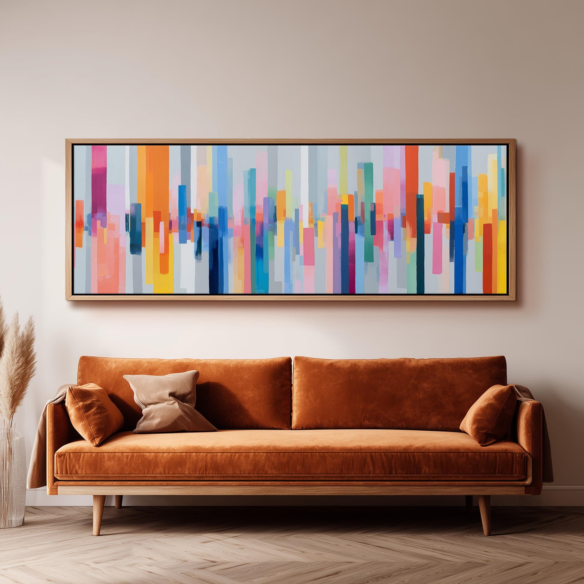 a large, abstract painting hanging on a wall above a brown sofa with two pillows.