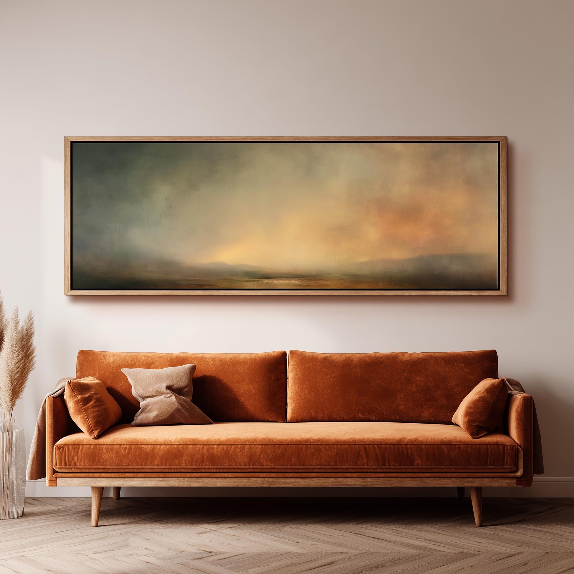 a large, rectangular painting hanging on a white wall above a brown sofa with two pillows.