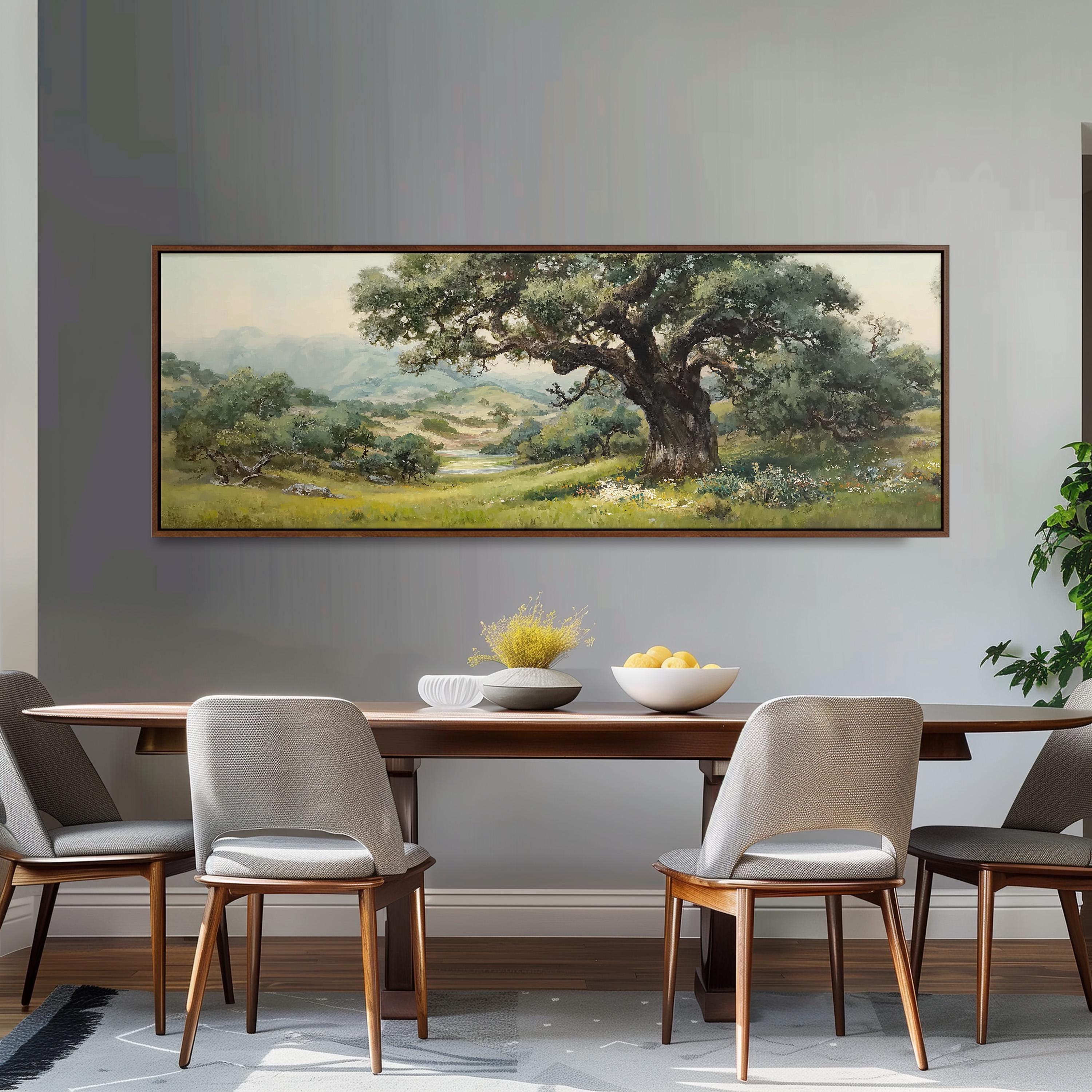a large painting of a lush green landscape hanging on a wall above a wooden dining table with four chairs. The painting depicts a serene countryside scene with a prominent tree in the foreground.