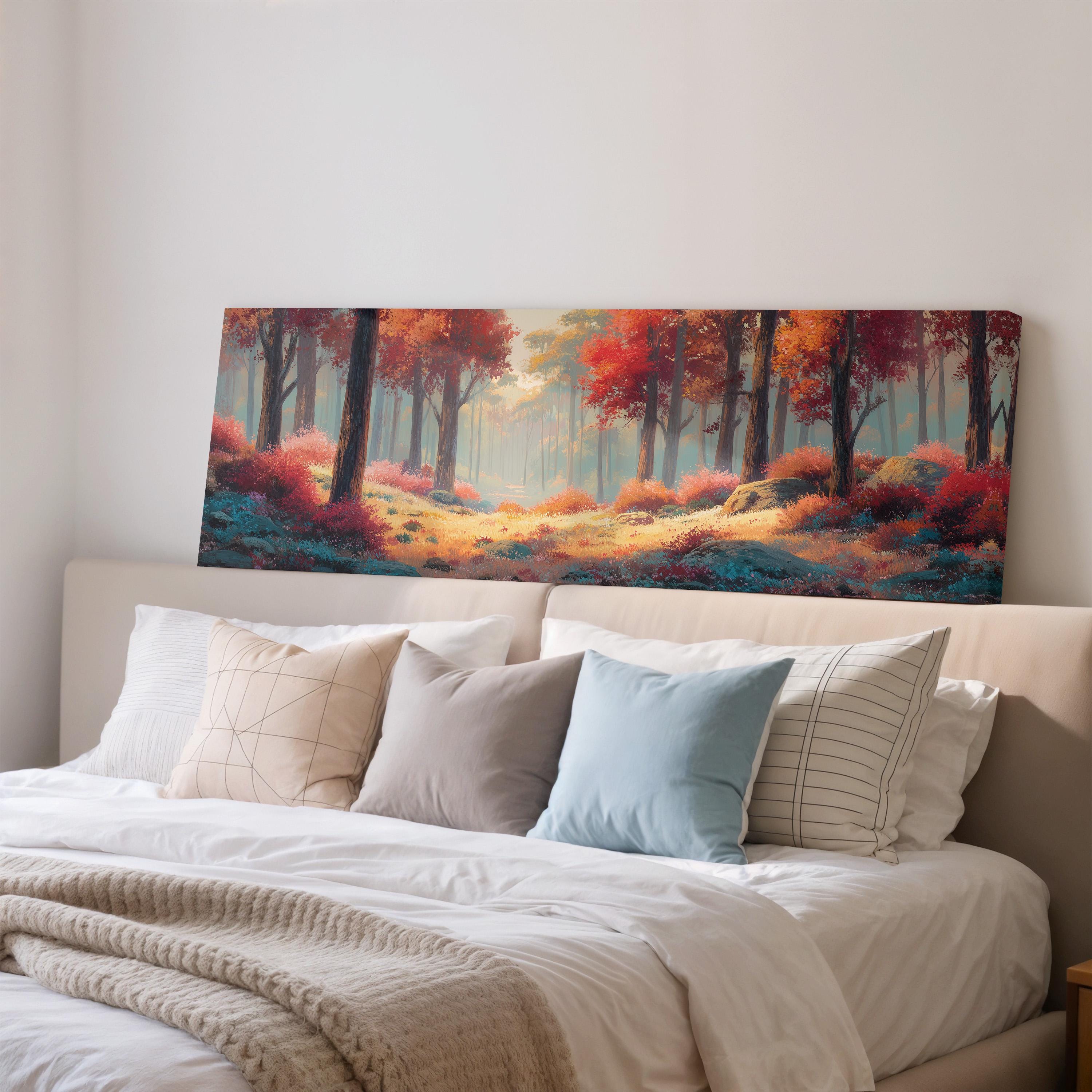 a large painting of a forest scene hanging on a wall above a bed with white pillows and a gray blanket.