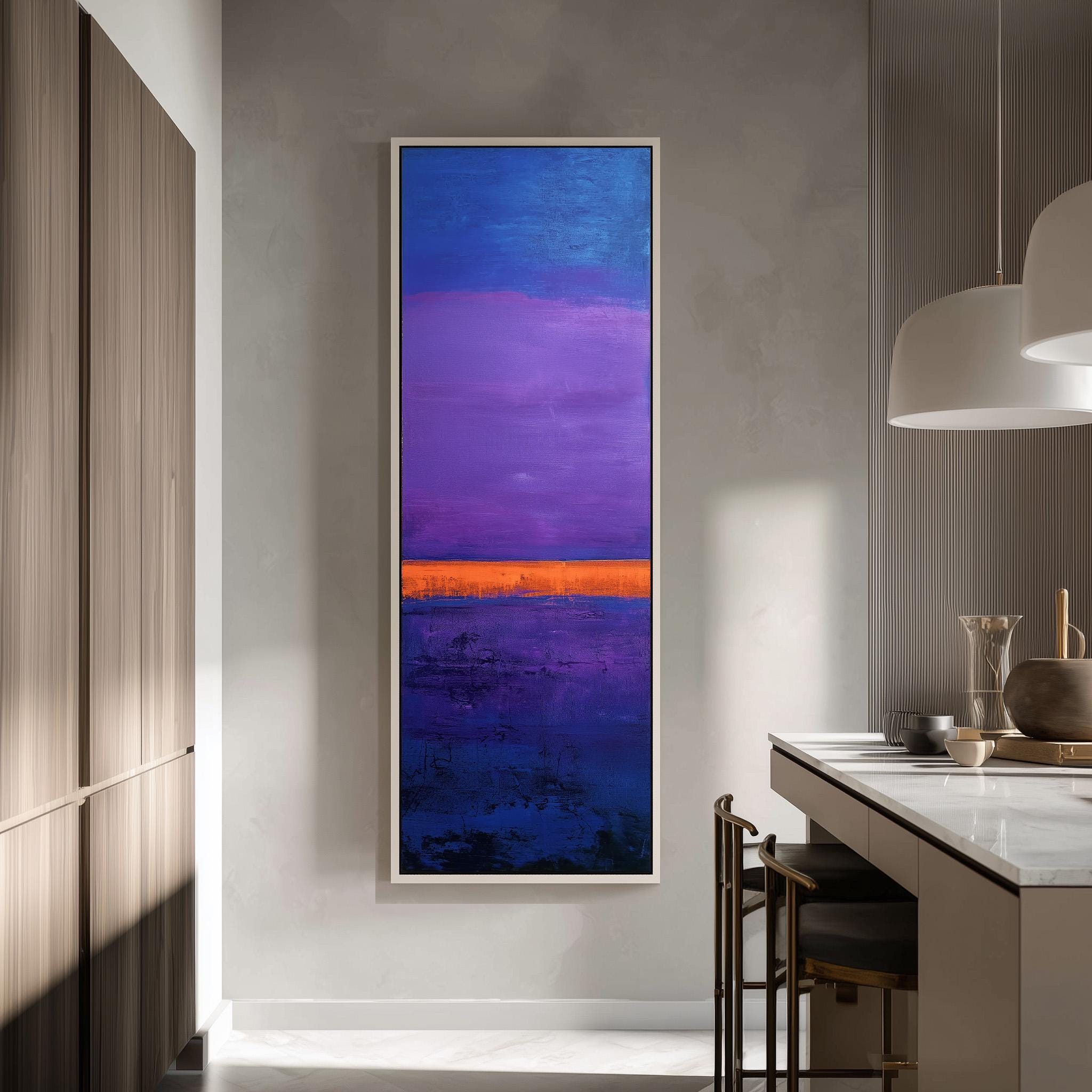 a modern kitchen with a large abstract painting hanging on the wall. The painting has a vibrant mix of blue, purple, and orange colors, creating a striking contrast against the neutral tones of the kitchen.