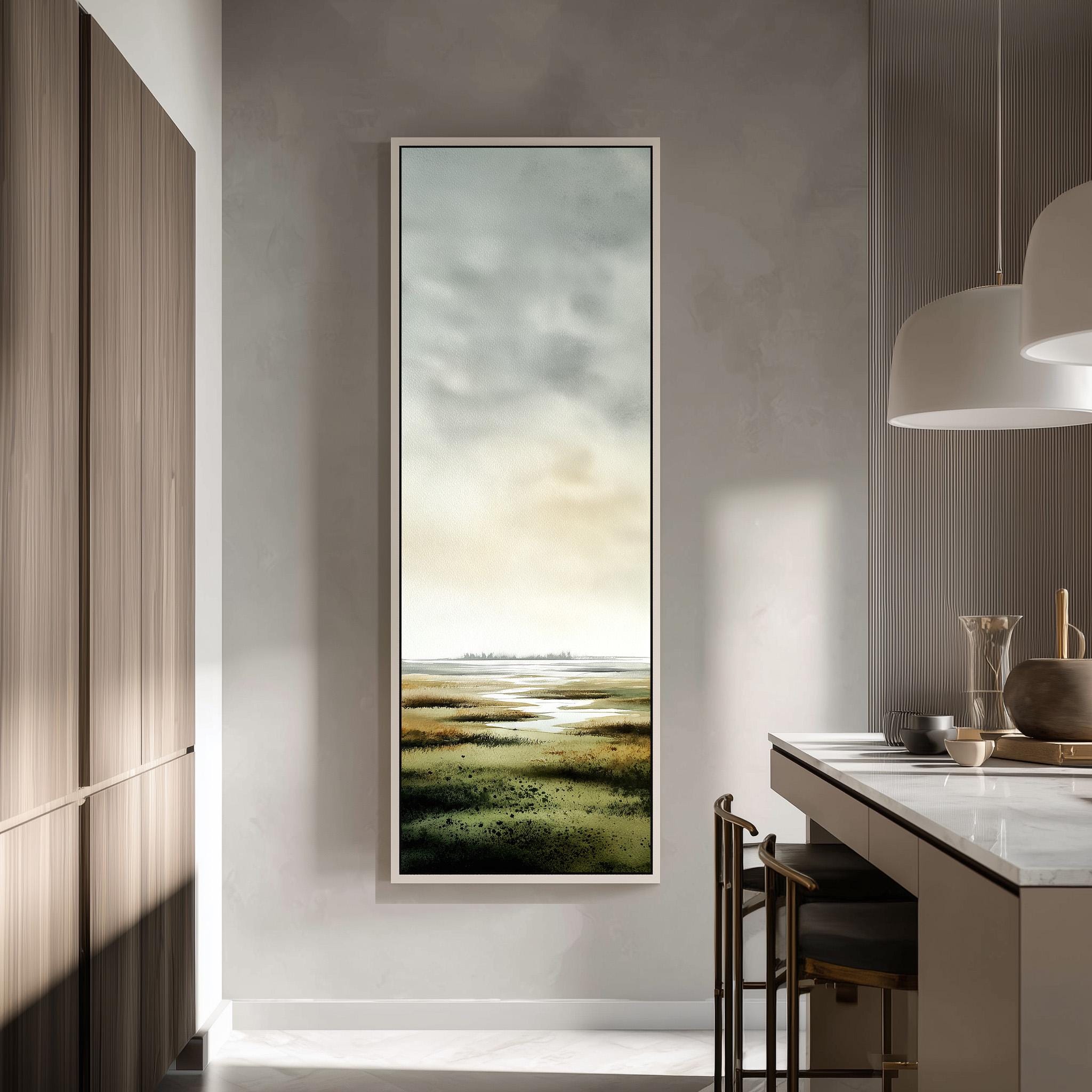 a modern kitchen with a large window that provides a view of a grassy field. The kitchen has a minimalist design with a white countertop and wooden cabinets. There is a painting hanging on the wall, adding an artistic touch to the space.