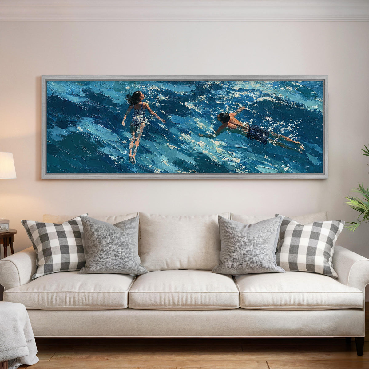 Two swimmers in turquoise waves panoramic canvas print above a white sofa in a bright living room