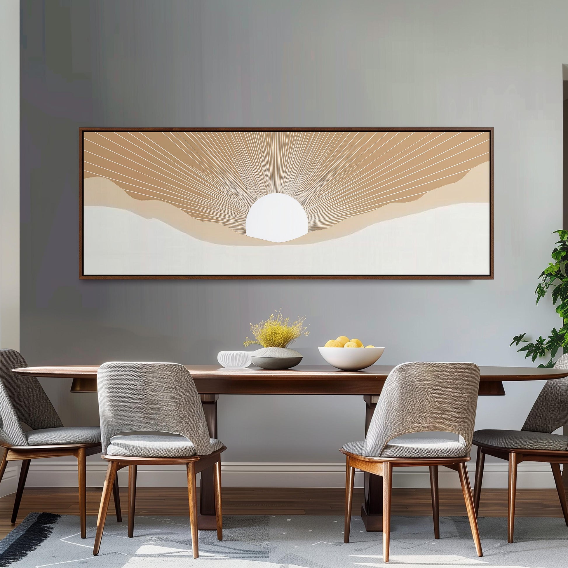 a dining room with a wooden table and four chairs, a large framed artwork depicting a sun-like design above the table, and a bowl of fruit on the table.