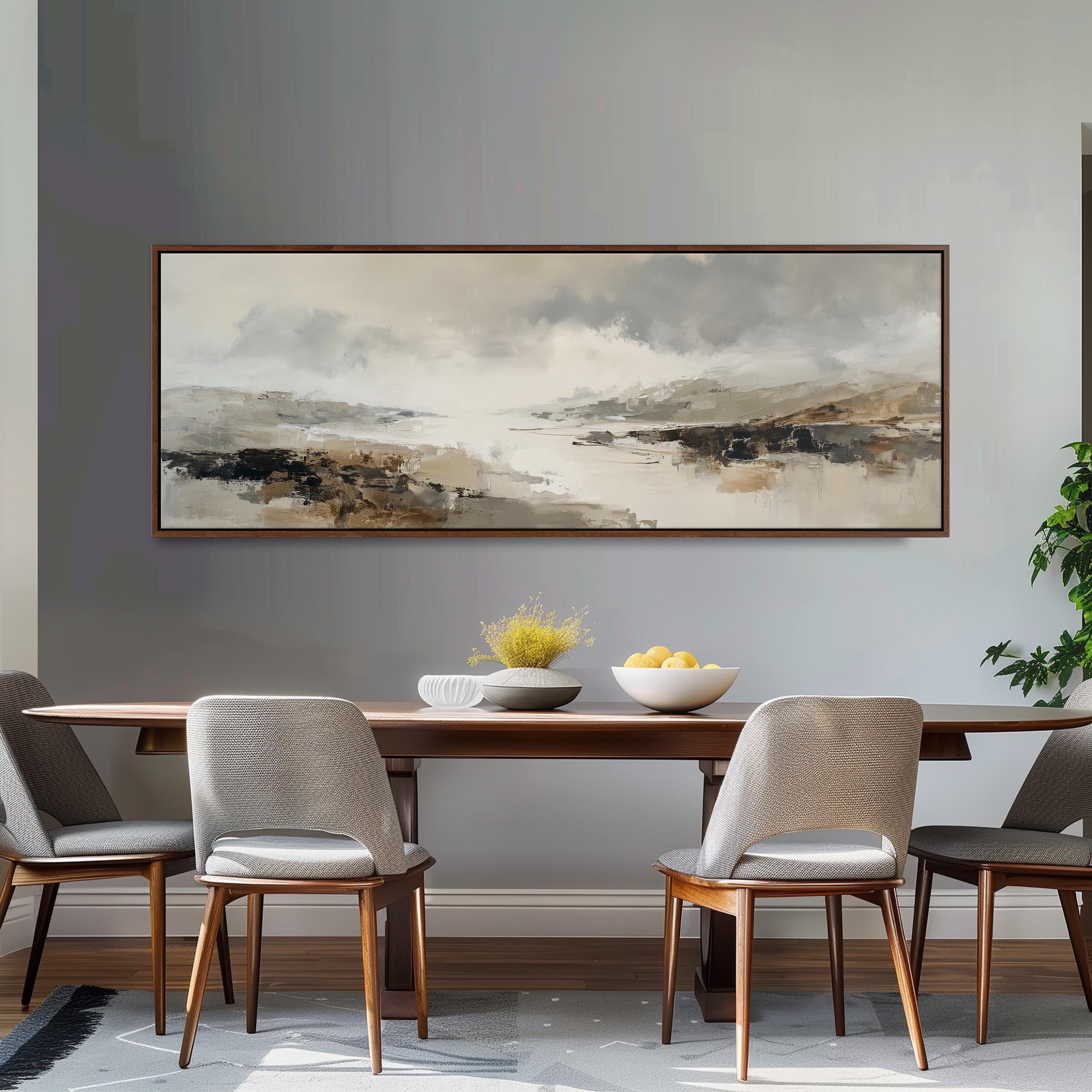 a dining room with a large painting hanging on the wall above a wooden table with four chairs. The painting depicts a landscape scene with mountains and a body of water.