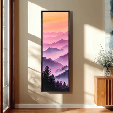 a large framed painting of a mountain landscape with a warm, colorful sky.