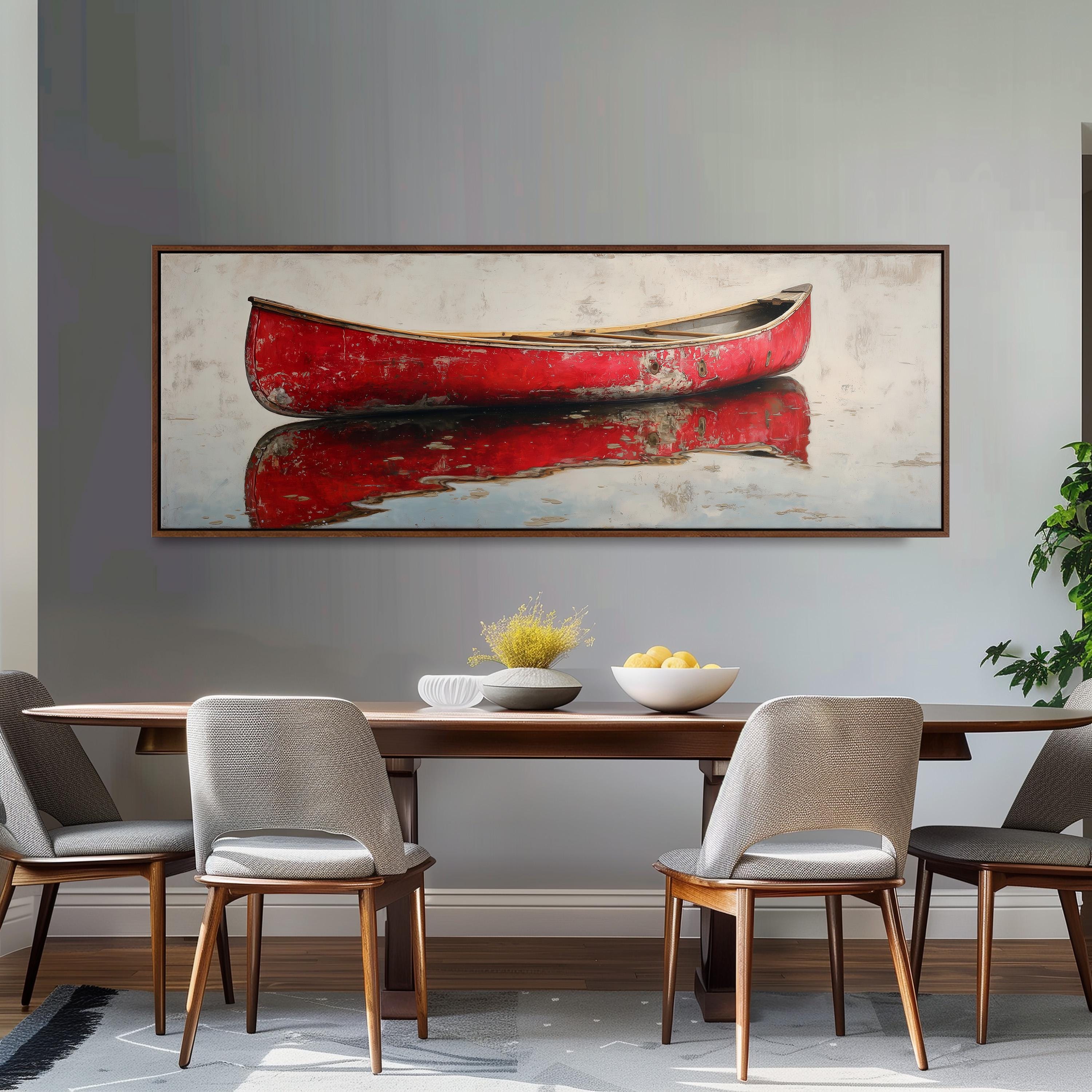 a dining room with a large, framed painting of a red canoe on the wall above a wooden dining table with four chairs. The table is set with a bowl of fruit and a vase of flowers, creating a cozy and inviting atmosphere.