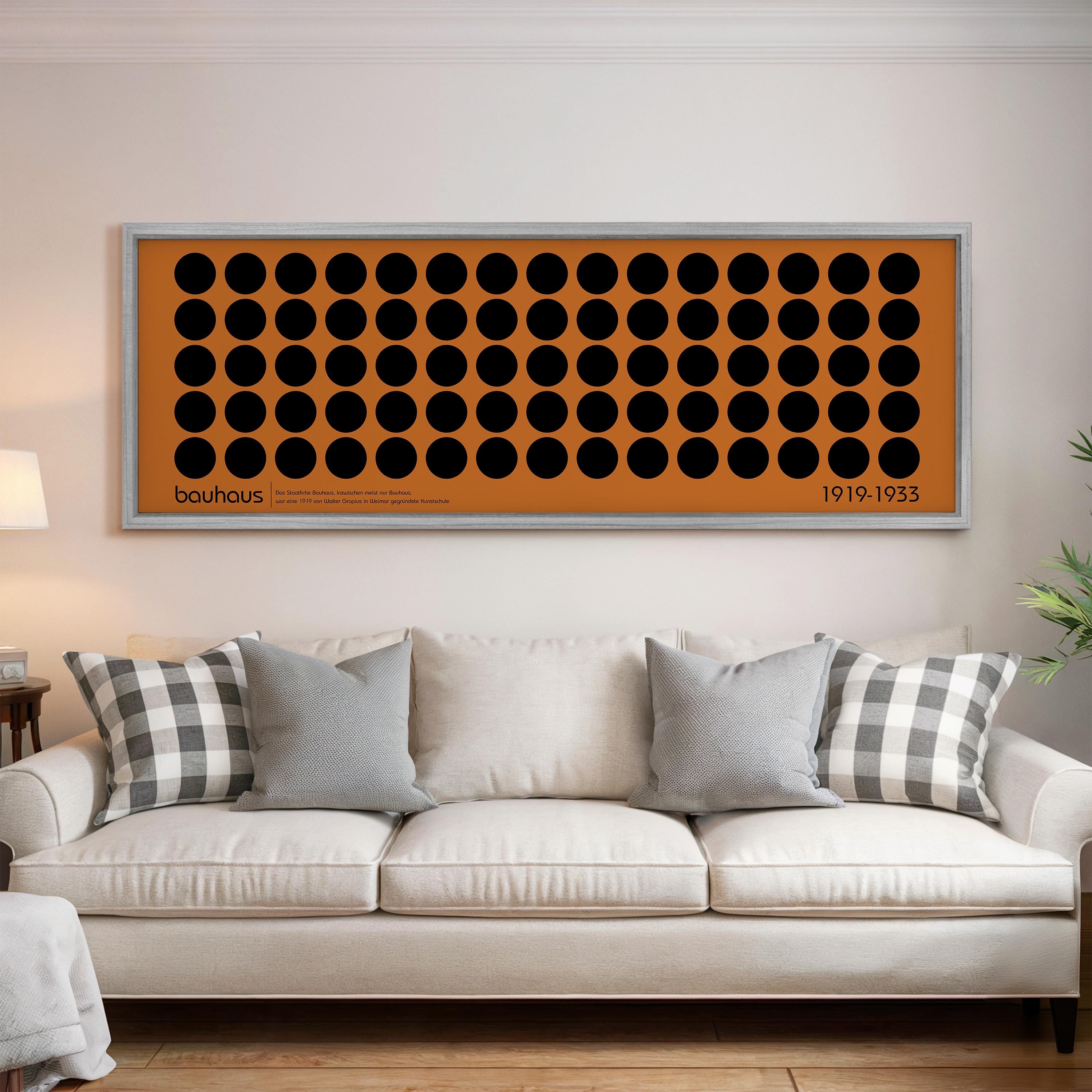 a large orange and black abstract art piece hanging on a white wall above a white couch with gray and white throw pillows.