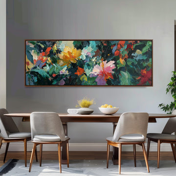 a dining room with a large, colorful painting hanging on the wall above a wooden dining table. The table is set with a bowl of fruit and a vase of flowers, creating a welcoming and vibrant atmosphere. The room is furnished with four chairs, two on each side of the table, and a potted plant is visible in the background.