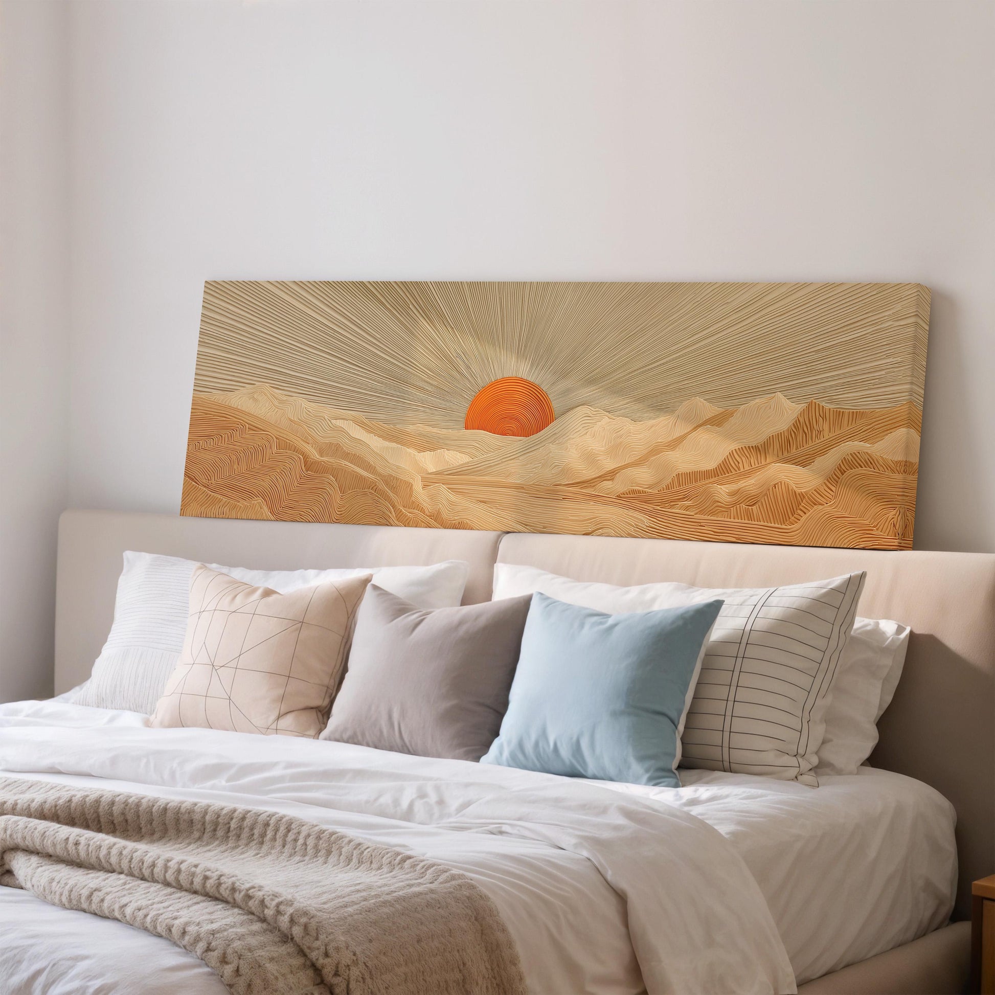 a large bed with a white comforter and pillows, and a large canvas print of a sunrise over mountains is displayed above the bed.