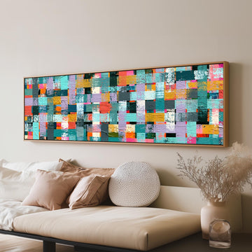 Woven grid of teal and pink blocks long horizontal canvas print above a sofa in a living room