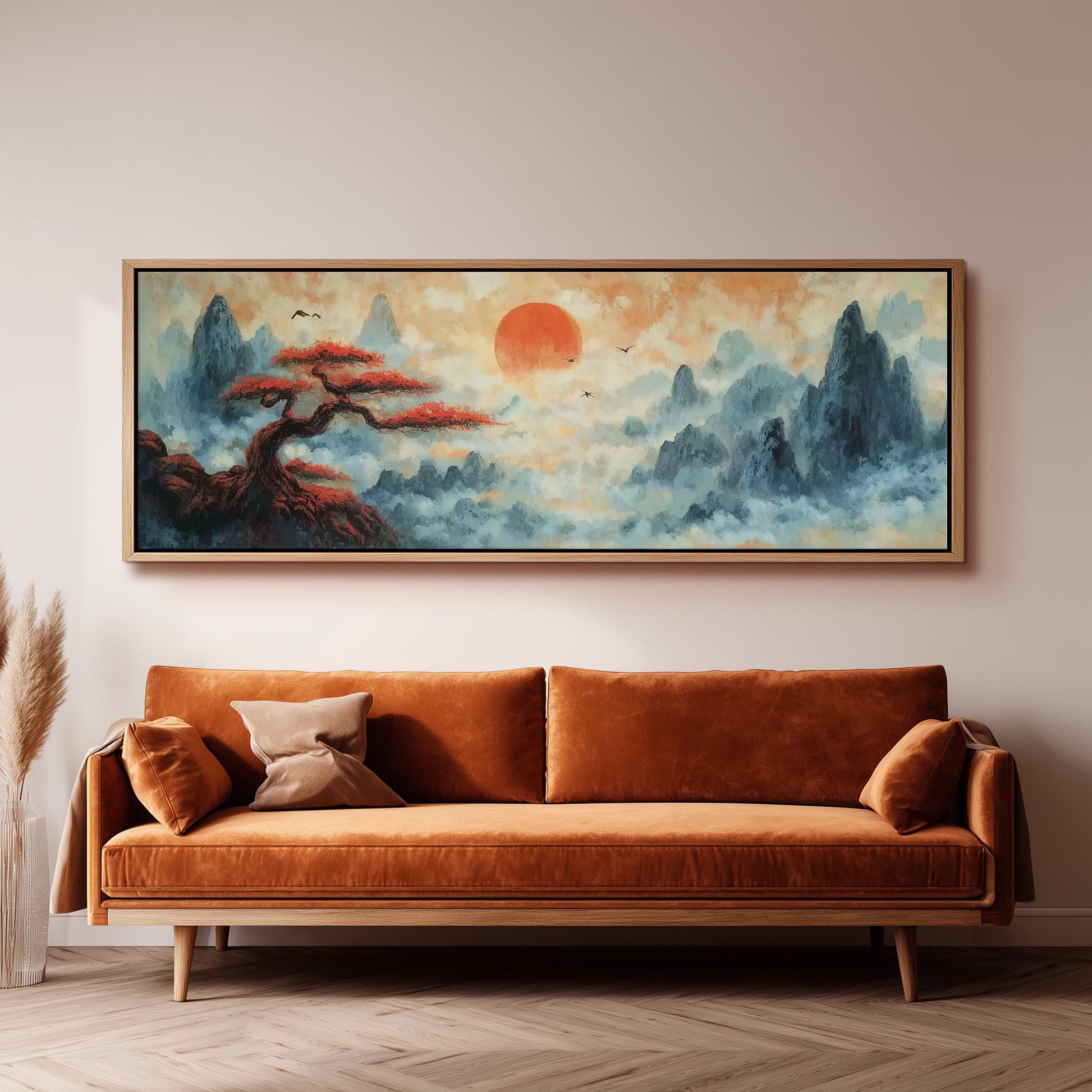 a large, framed painting of a serene landscape with a tree and mountains, hanging on a wall above a brown sofa.