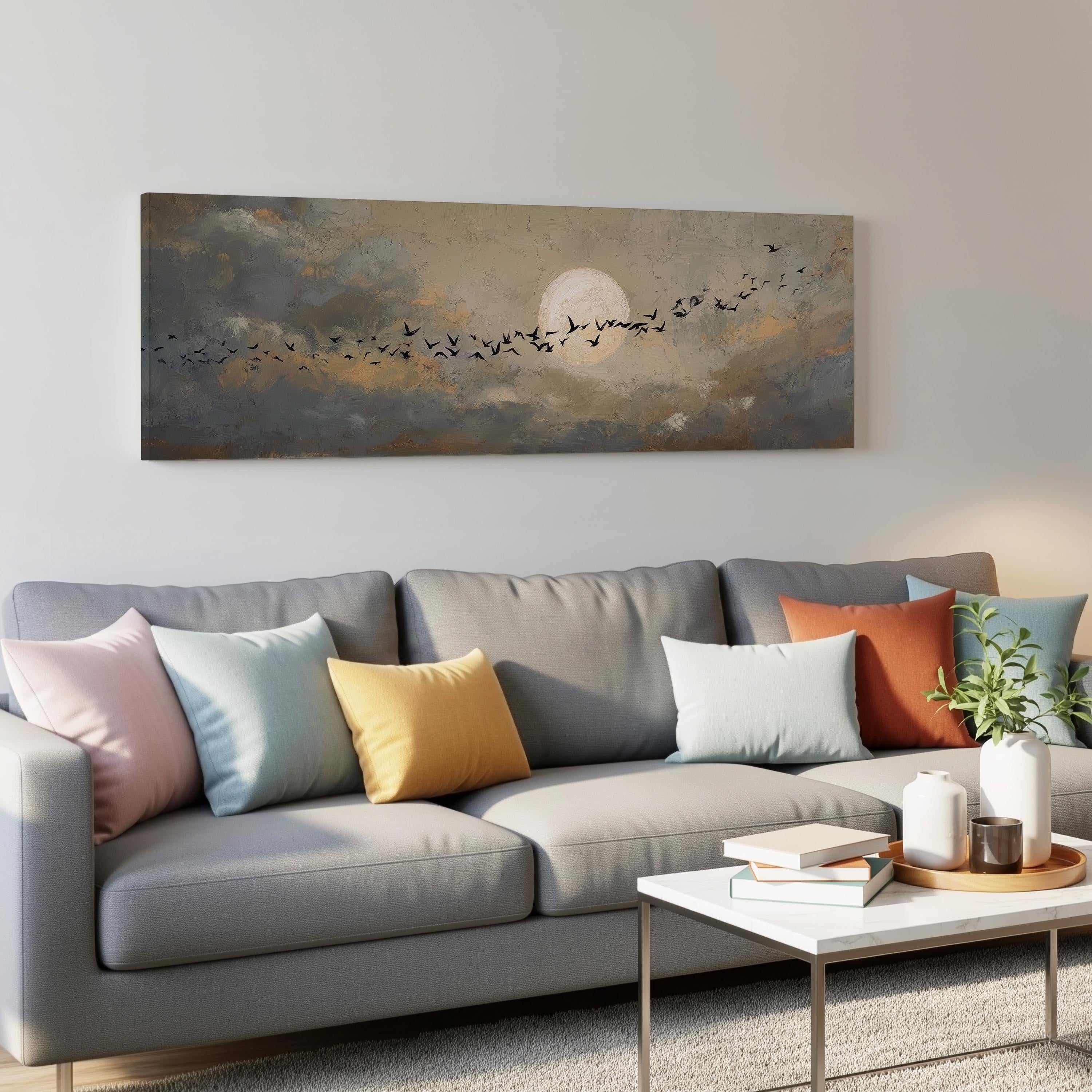 a gray couch with colorful throw pillows, a coffee table, and a painting of a flock of birds flying across a cloudy sky above it.