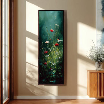 a large painting of red flowers hanging on a wall, with a wooden cabinet and a vase of flowers to the right of the painting.