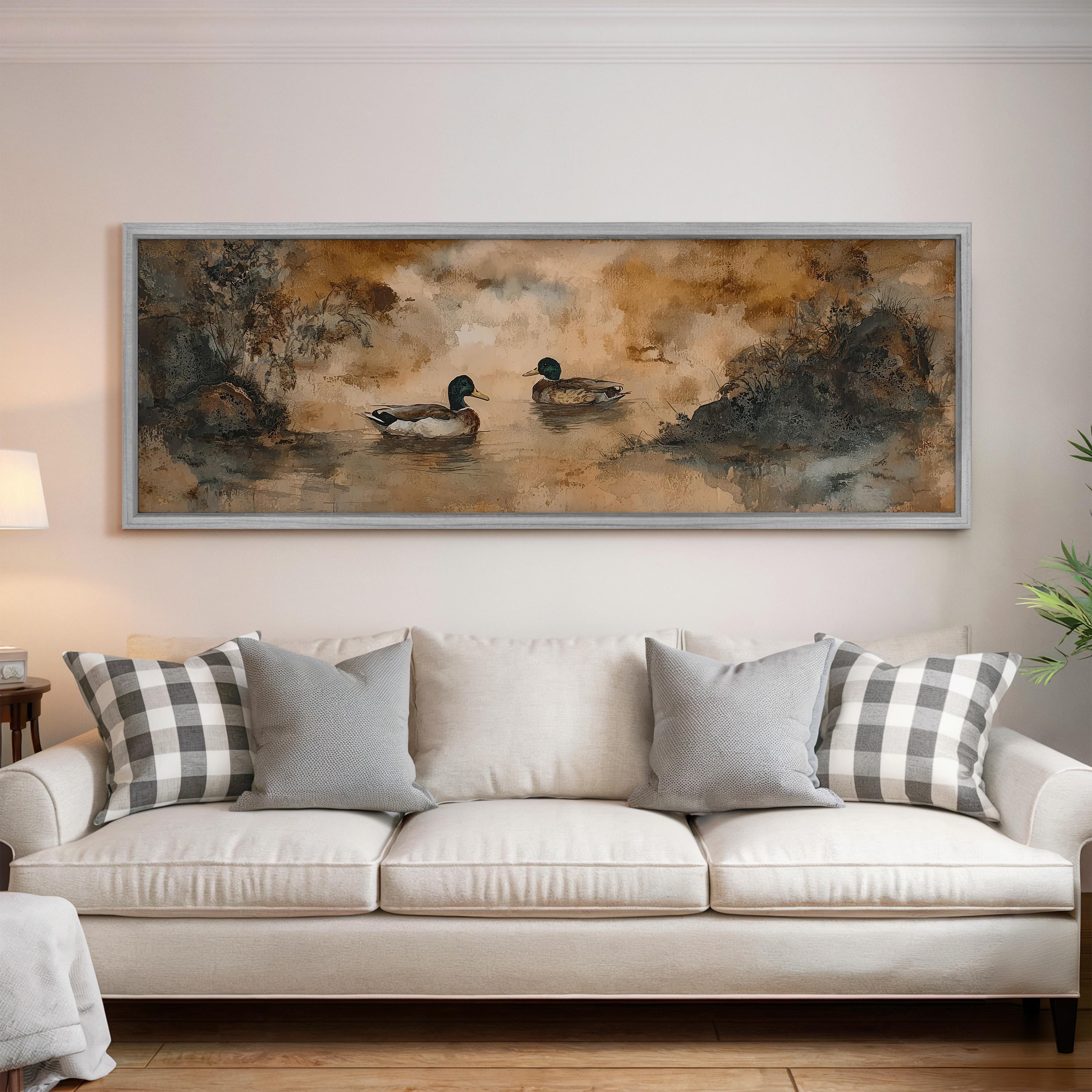 a large painting of ducks swimming in a pond, hanging on a wall above a white couch with gray and white plaid throw pillows.