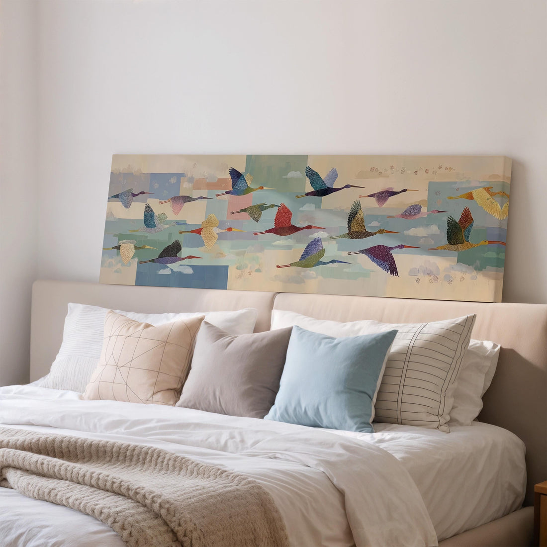 a large, colorful painting of birds in flight hanging on a wall above a brown sofa.