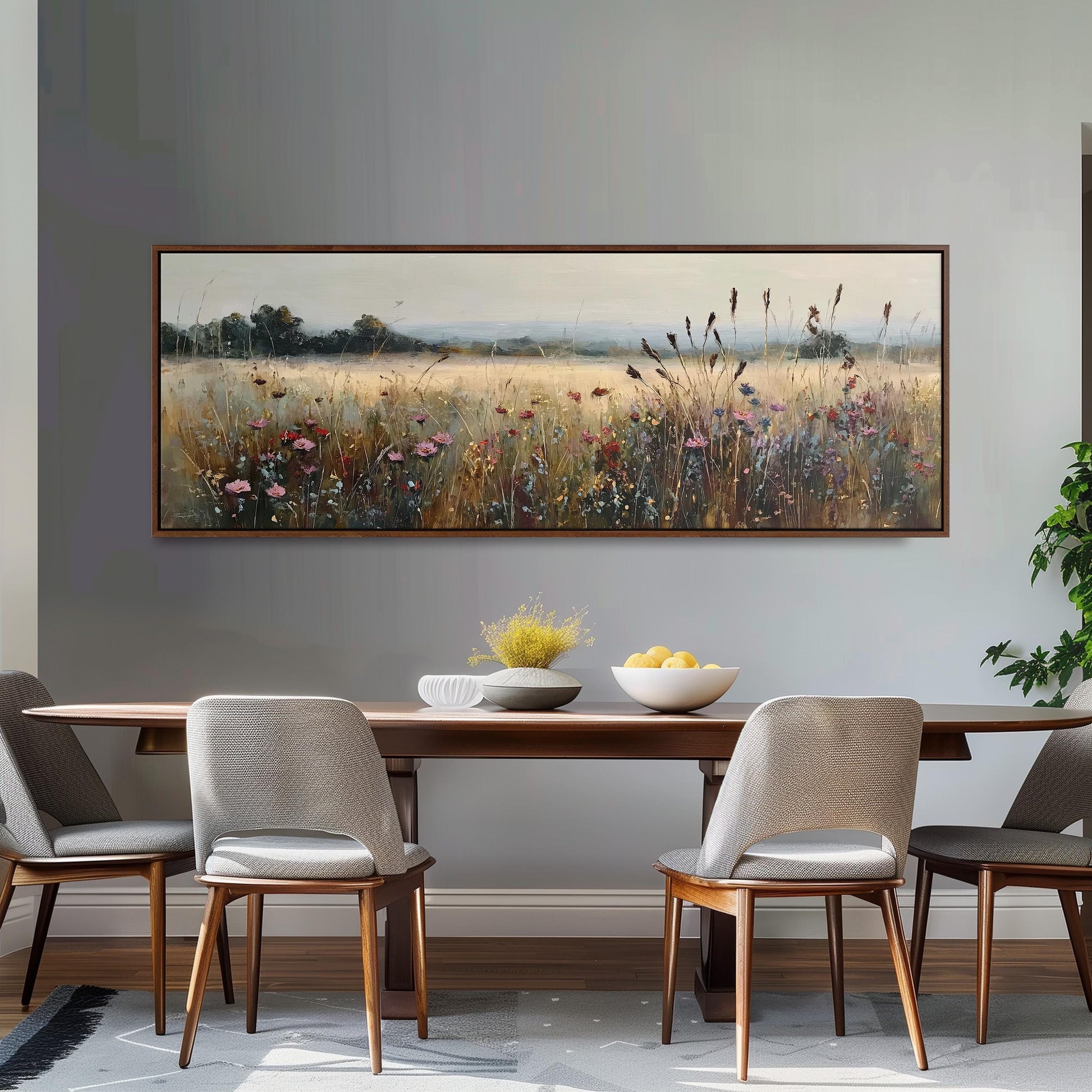 a dining room with a large painting of a field of flowers hanging on the wall above a wooden dining table with four chairs. The table is set with a bowl of fruit and a vase of flowers, creating a cozy and inviting atmosphere.